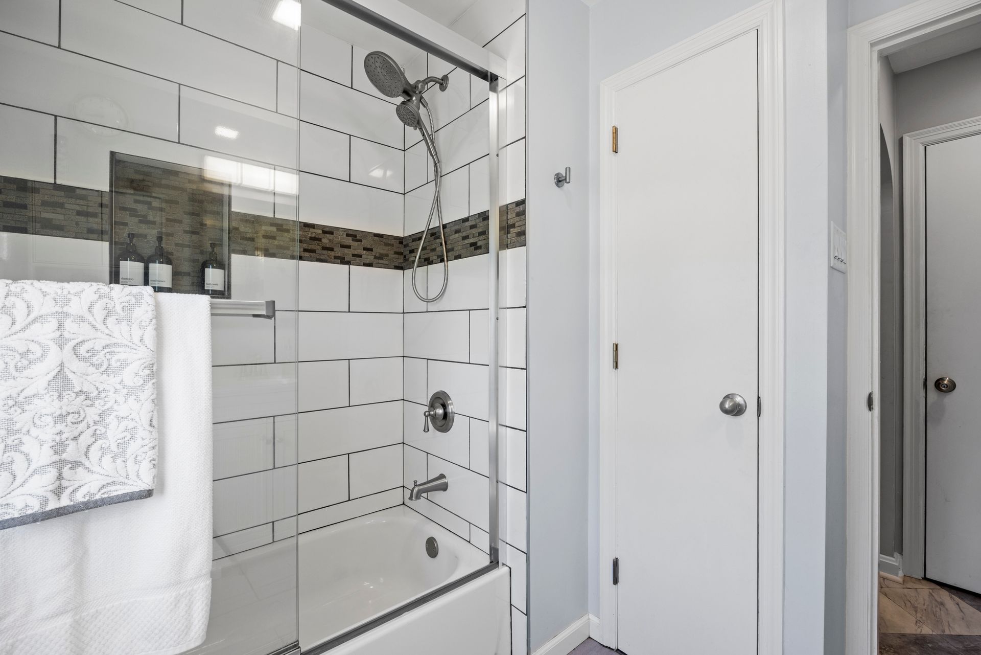 A bathroom with a bathtub and a shower with a glass door.