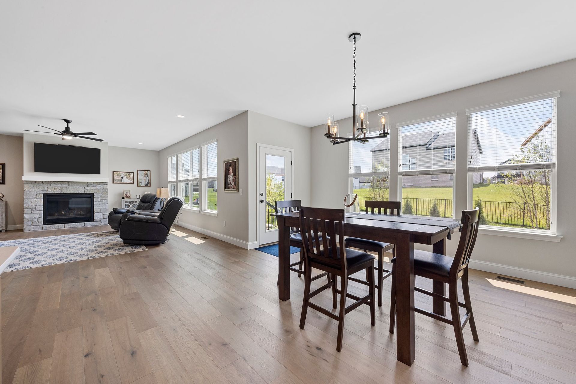A living room with a dining table and chairs and a fireplace.