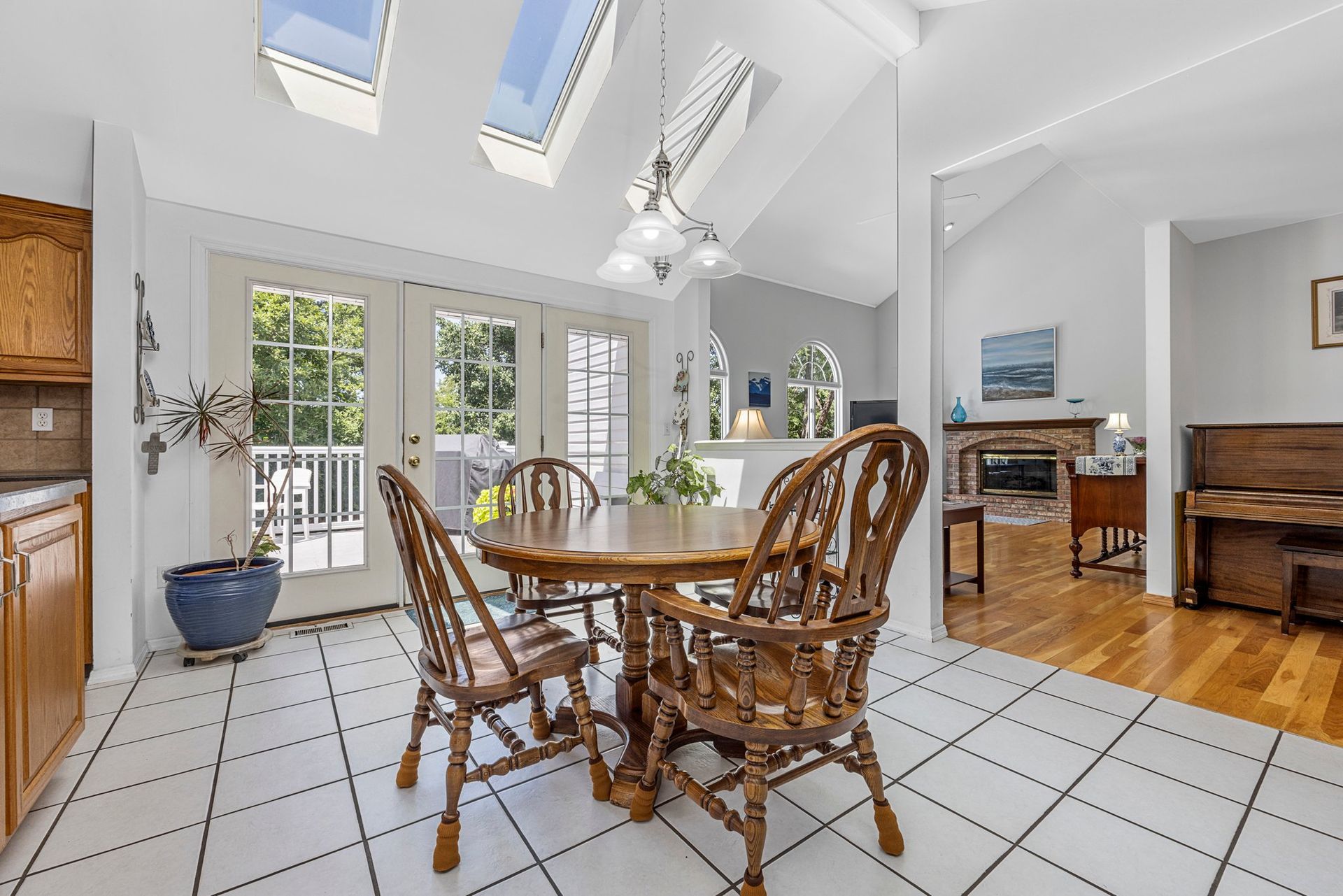 A dining room with a table and chairs and a skylight.