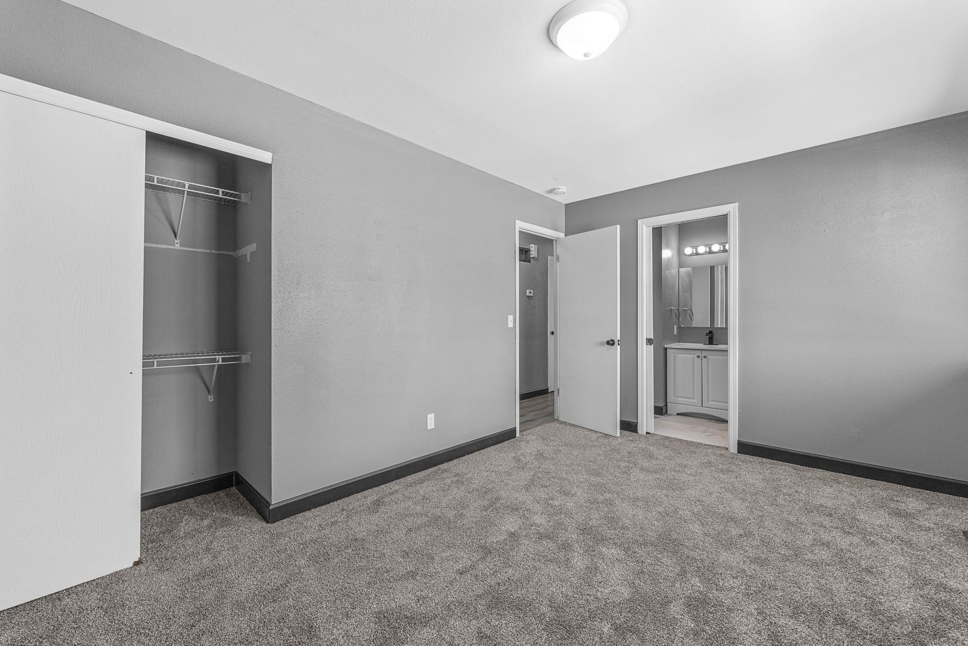 An empty bedroom with a walk in closet and a bathroom.