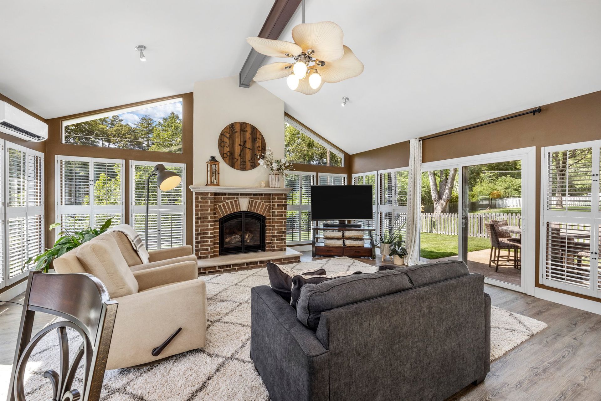 A living room with a couch , chair , television and fireplace.