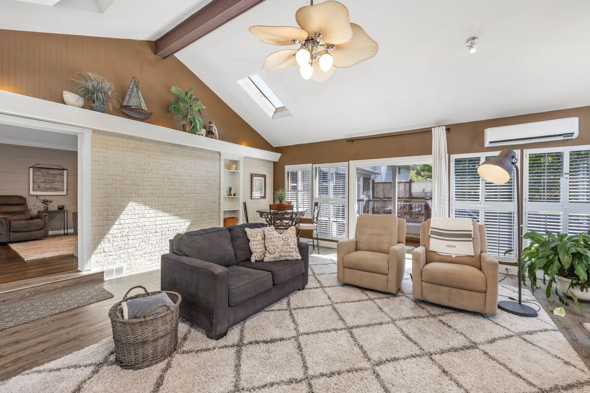 A living room with a couch , chairs , and a ceiling fan.
