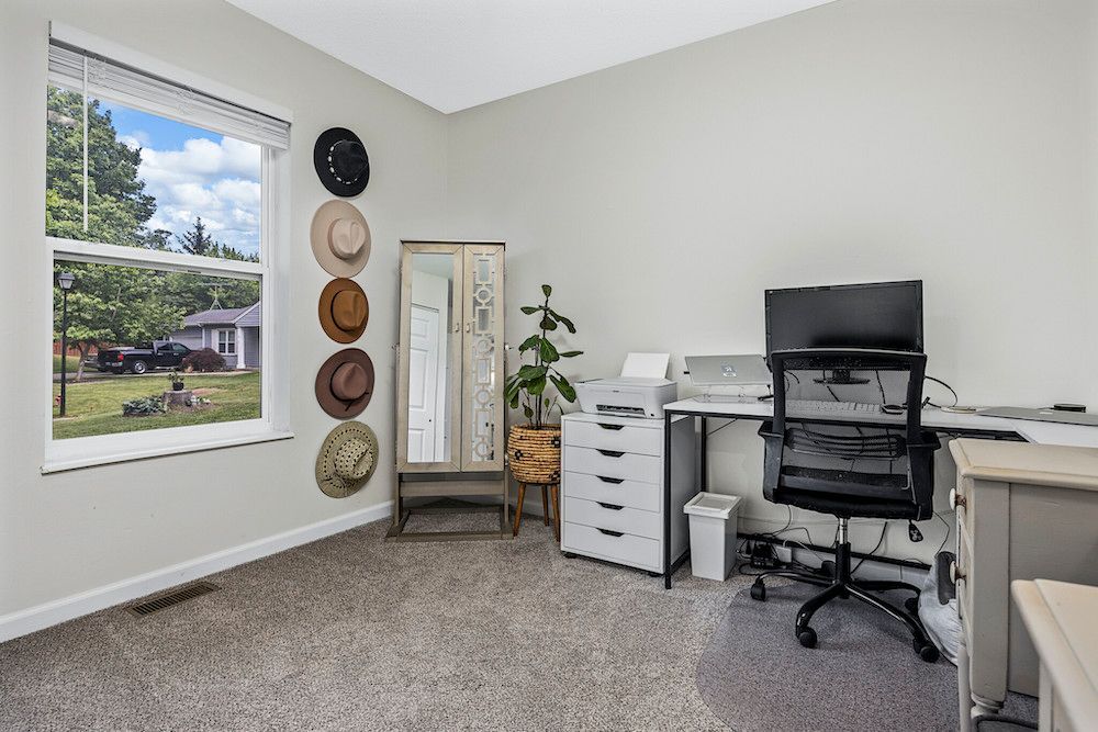 A room with a desk , chair , computer and a window.
