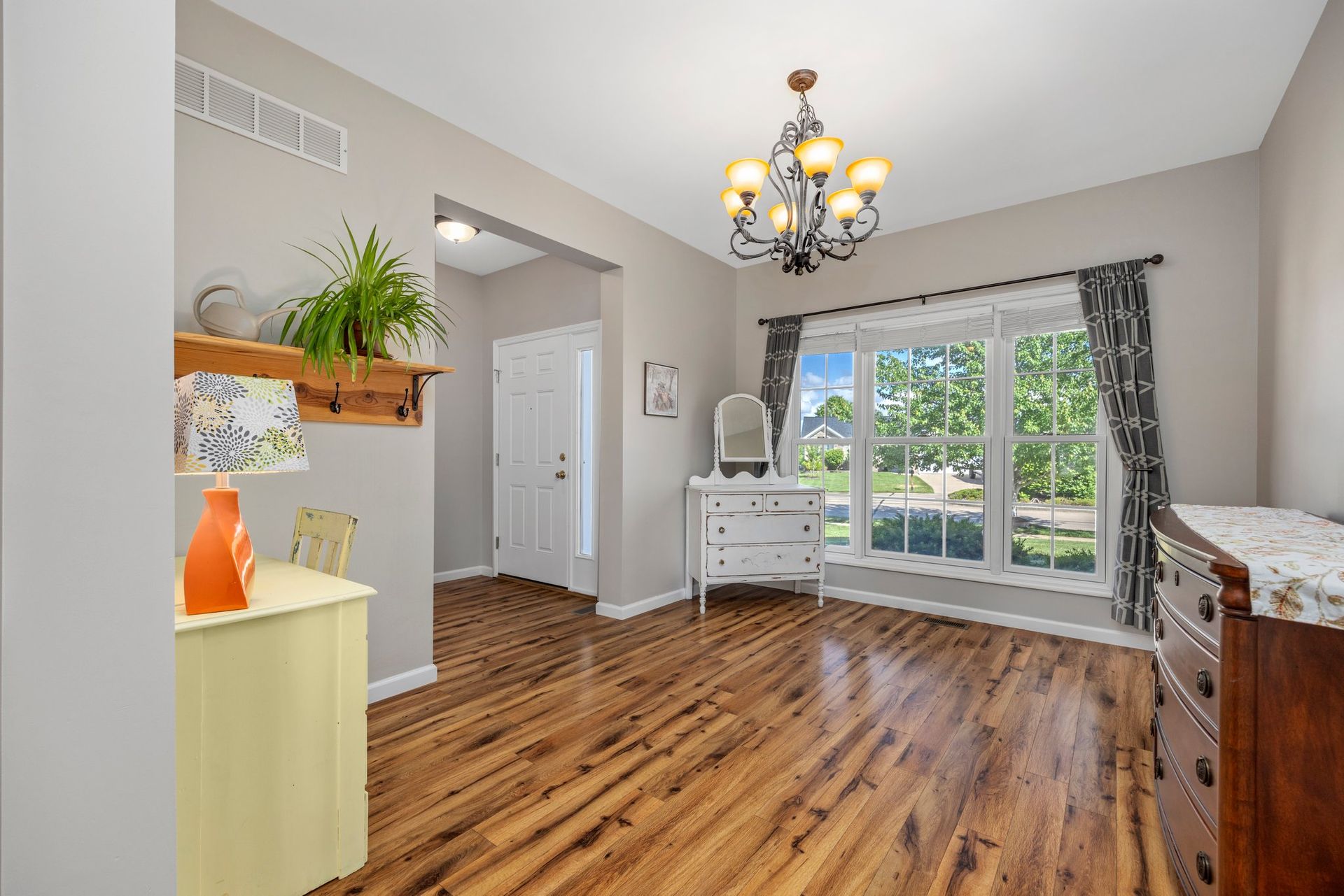 A living room with hardwood floors and a chandelier.