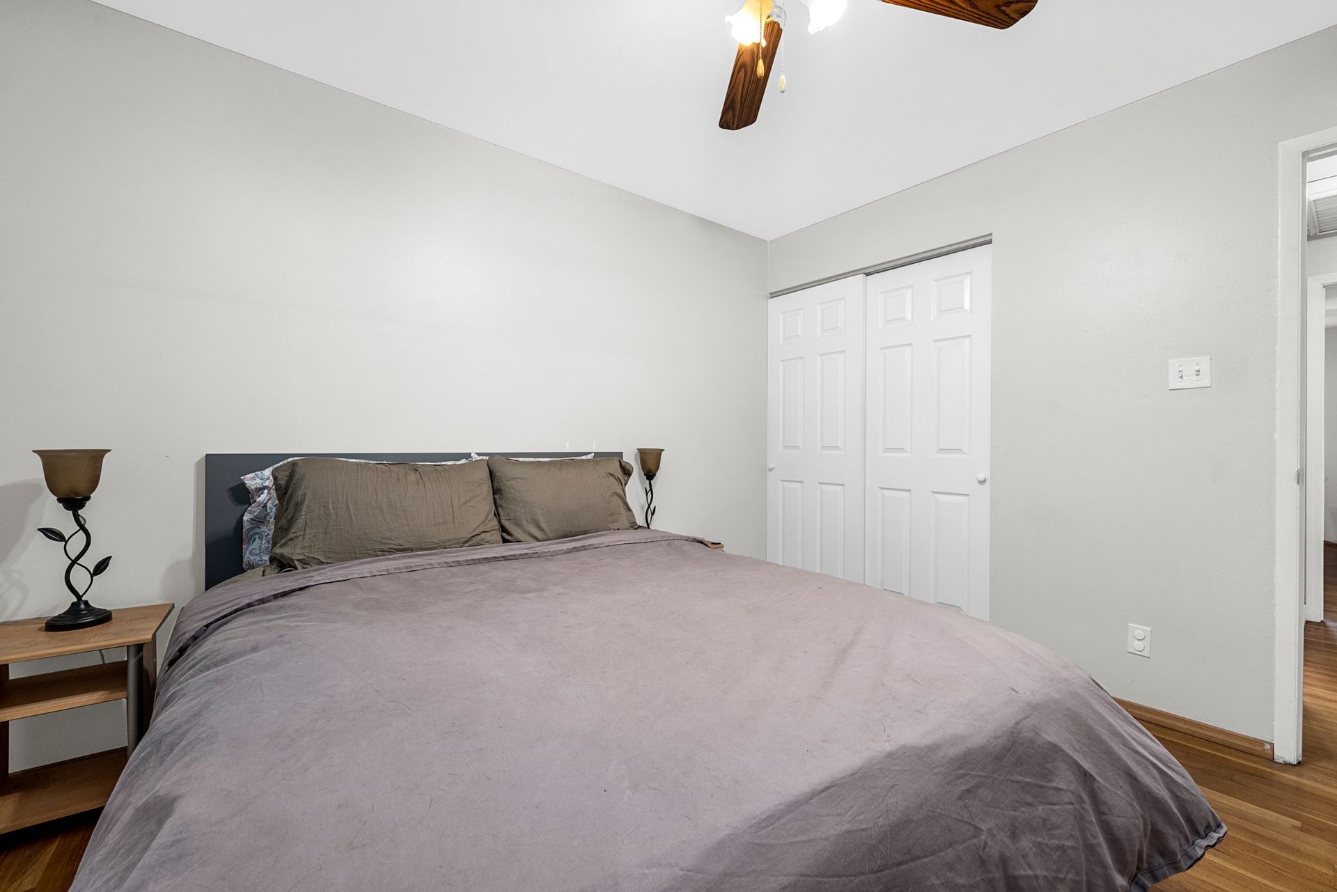 A bedroom with a large bed and a ceiling fan.
