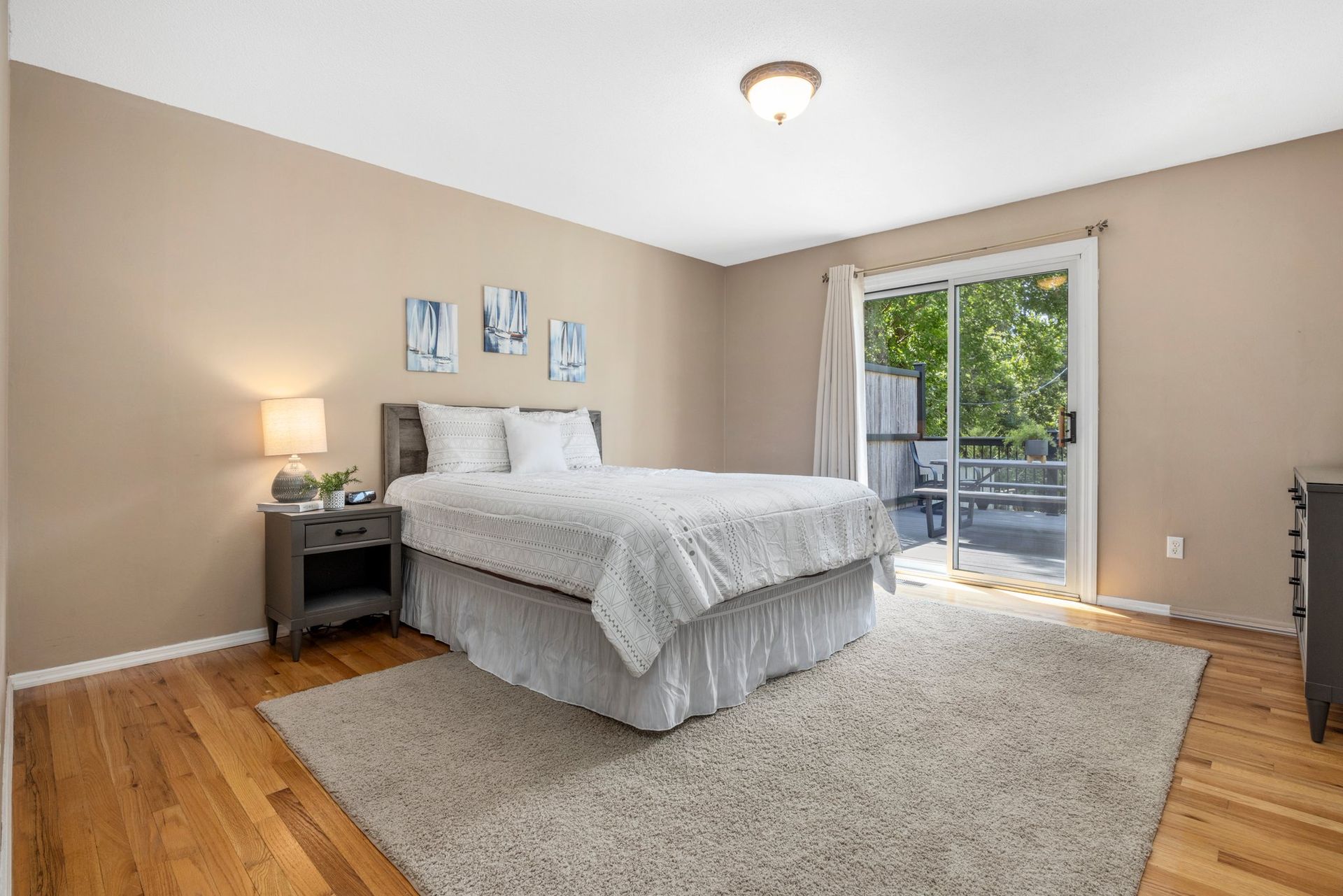 A bedroom with a king size bed and a sliding glass door.
