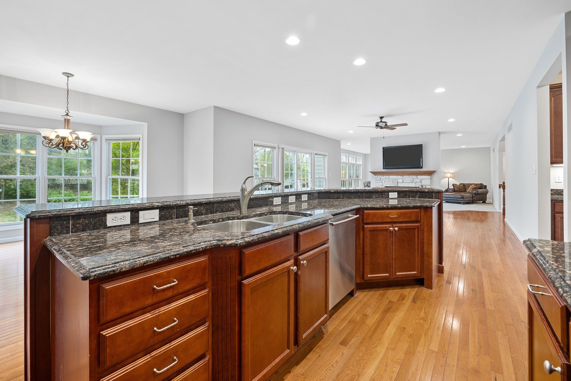 A kitchen with a large island and granite counter tops.