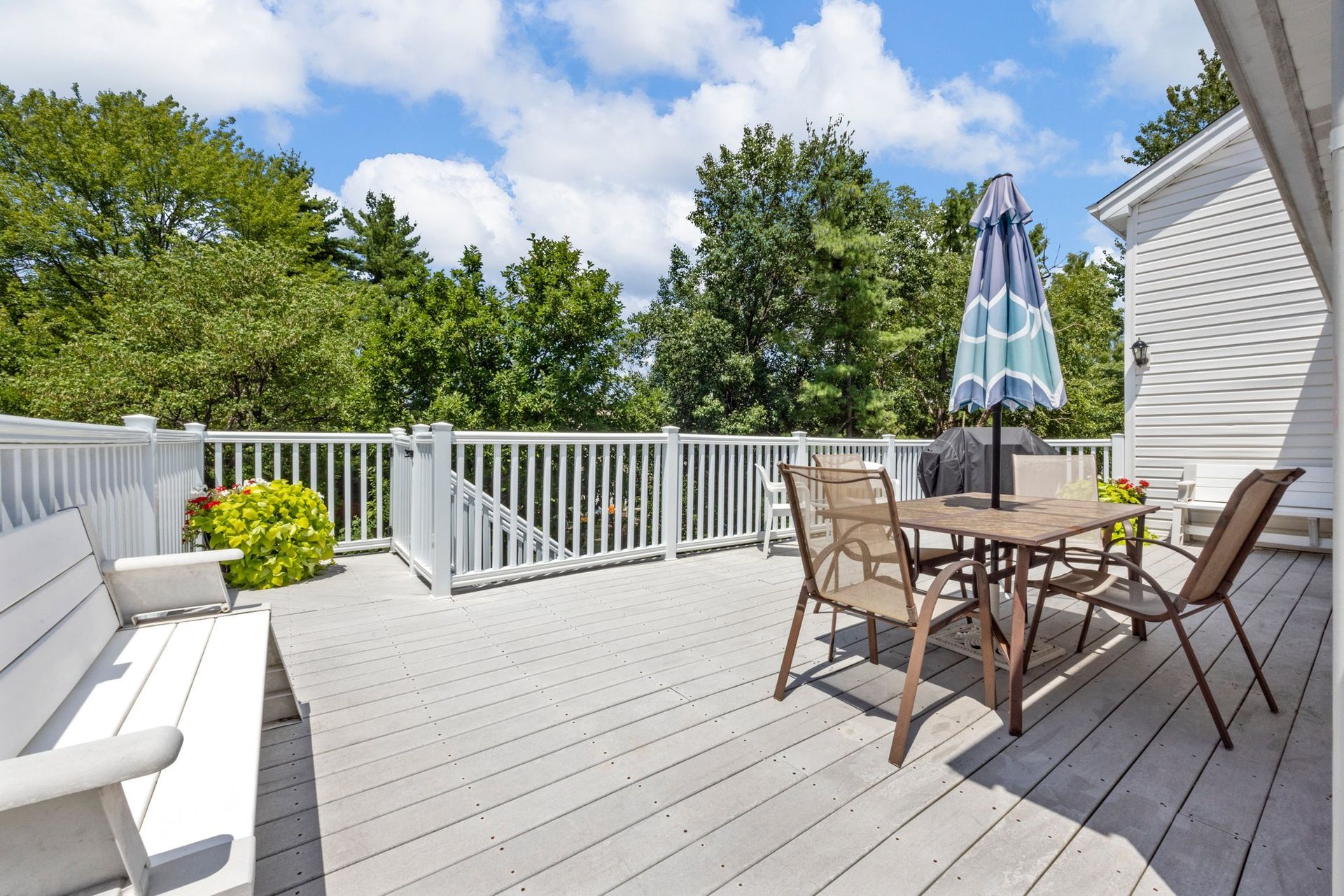 A deck with a table and chairs and an umbrella