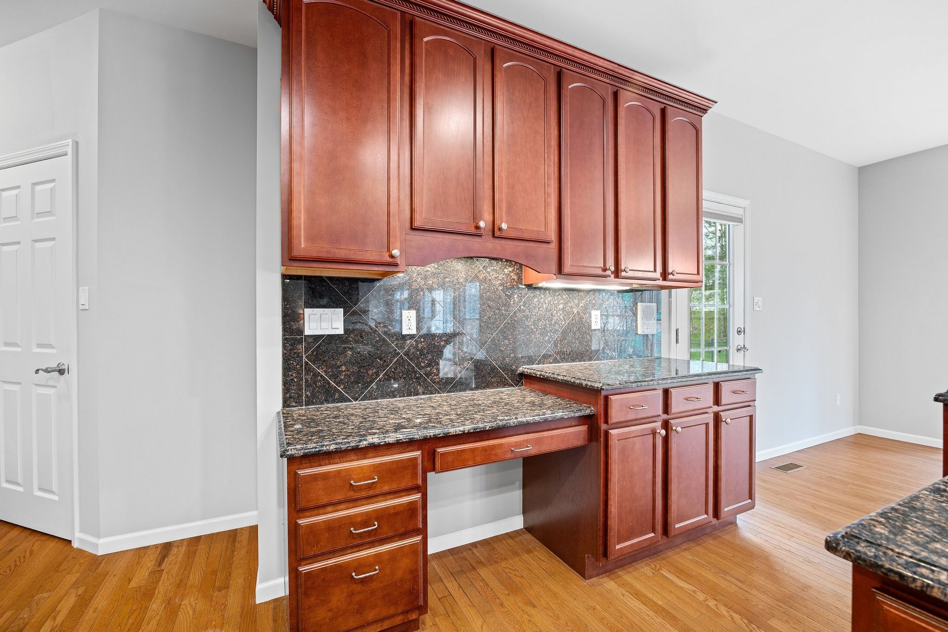 A kitchen with wooden cabinets and granite counter tops.