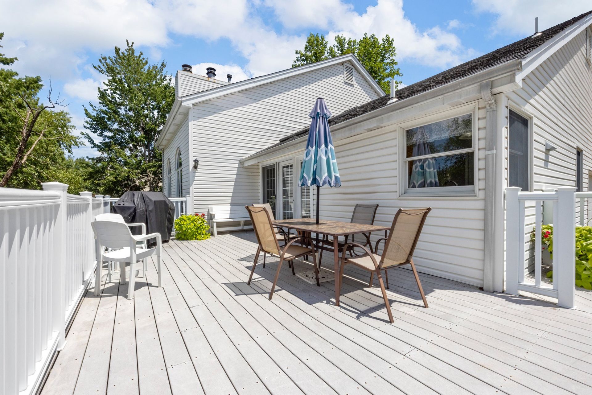 There is a large deck with a table and chairs on it.