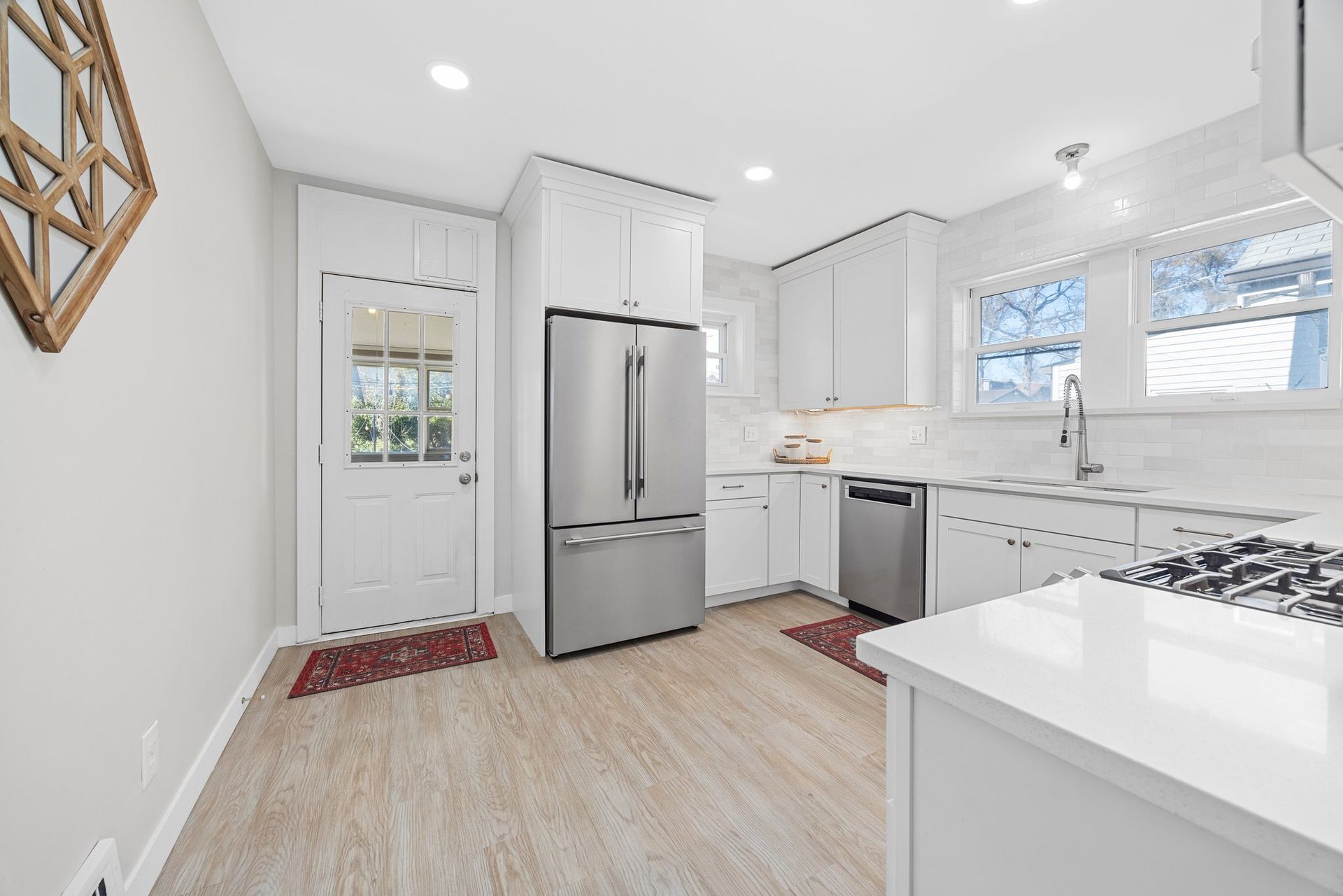 A kitchen with white cabinets and stainless steel appliances.