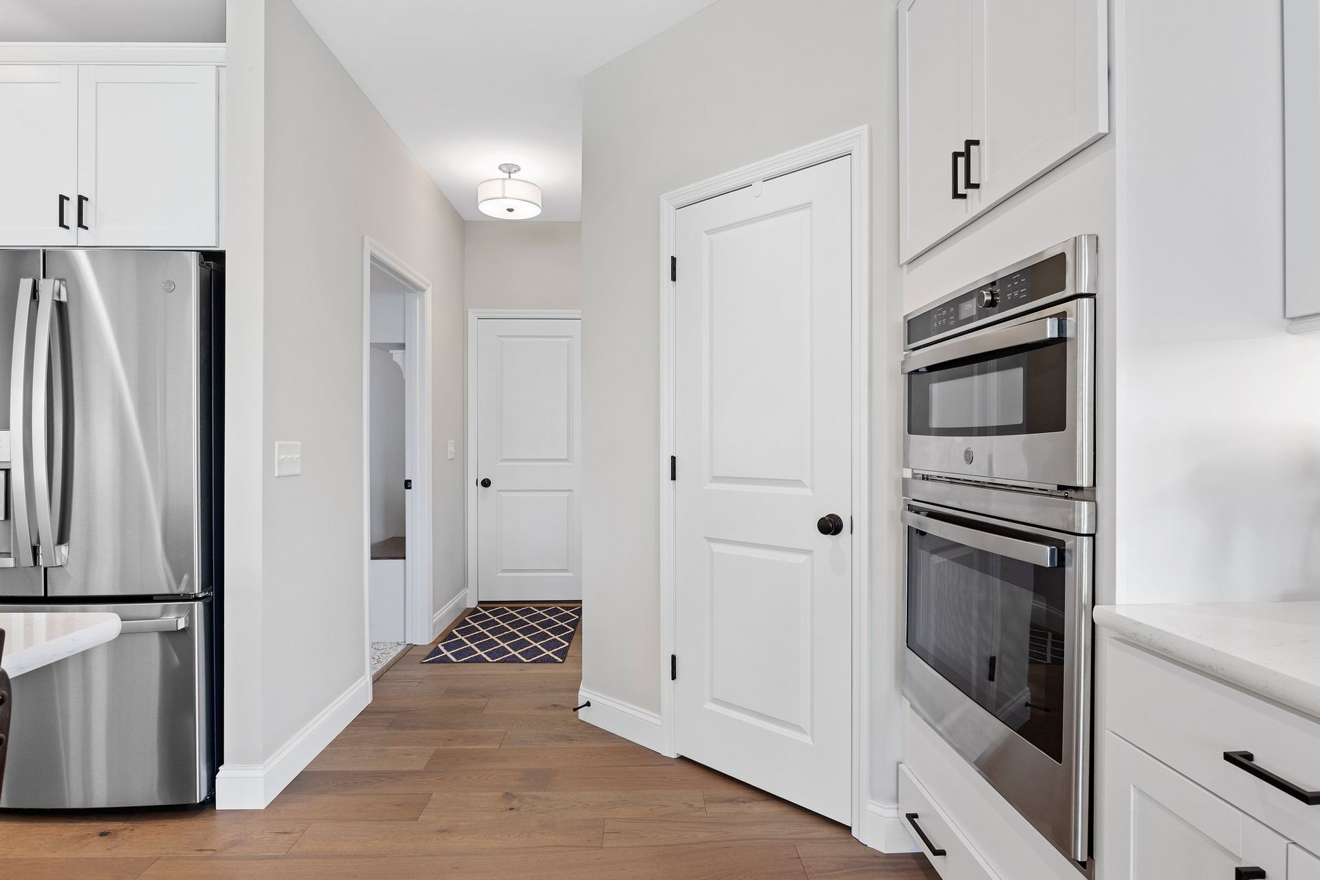 A kitchen with stainless steel appliances and white cabinets.