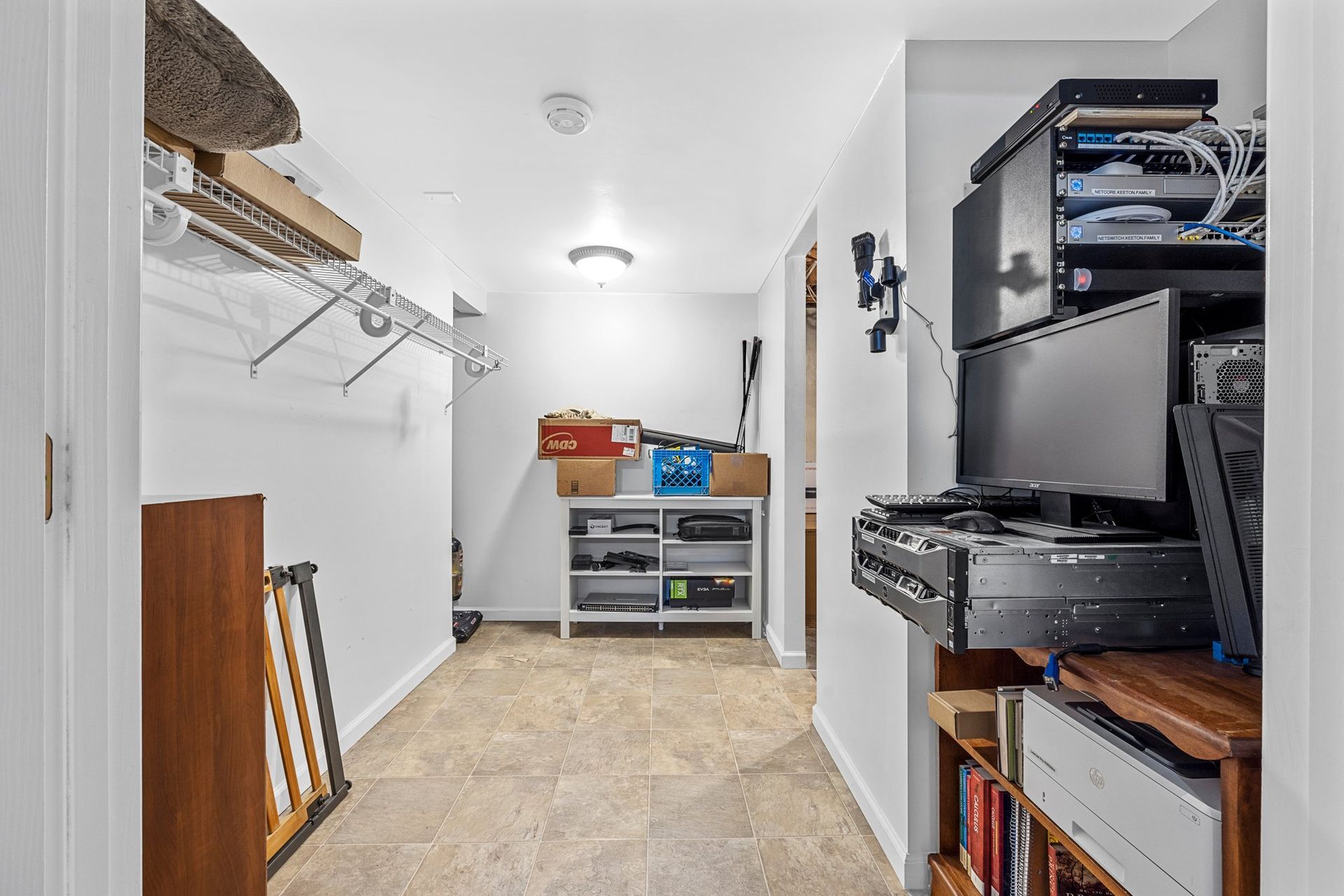 A closet filled with lots of boxes and a computer on a desk.