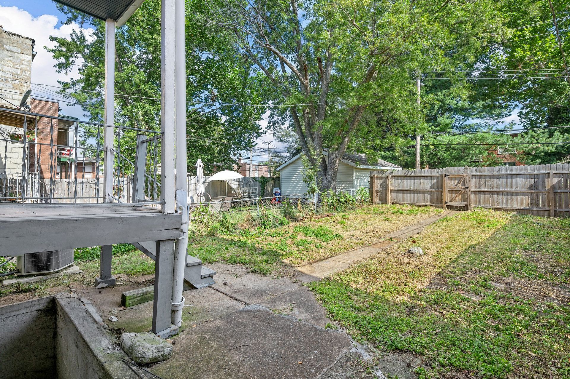 The backyard of a house with a fence and a porch.
