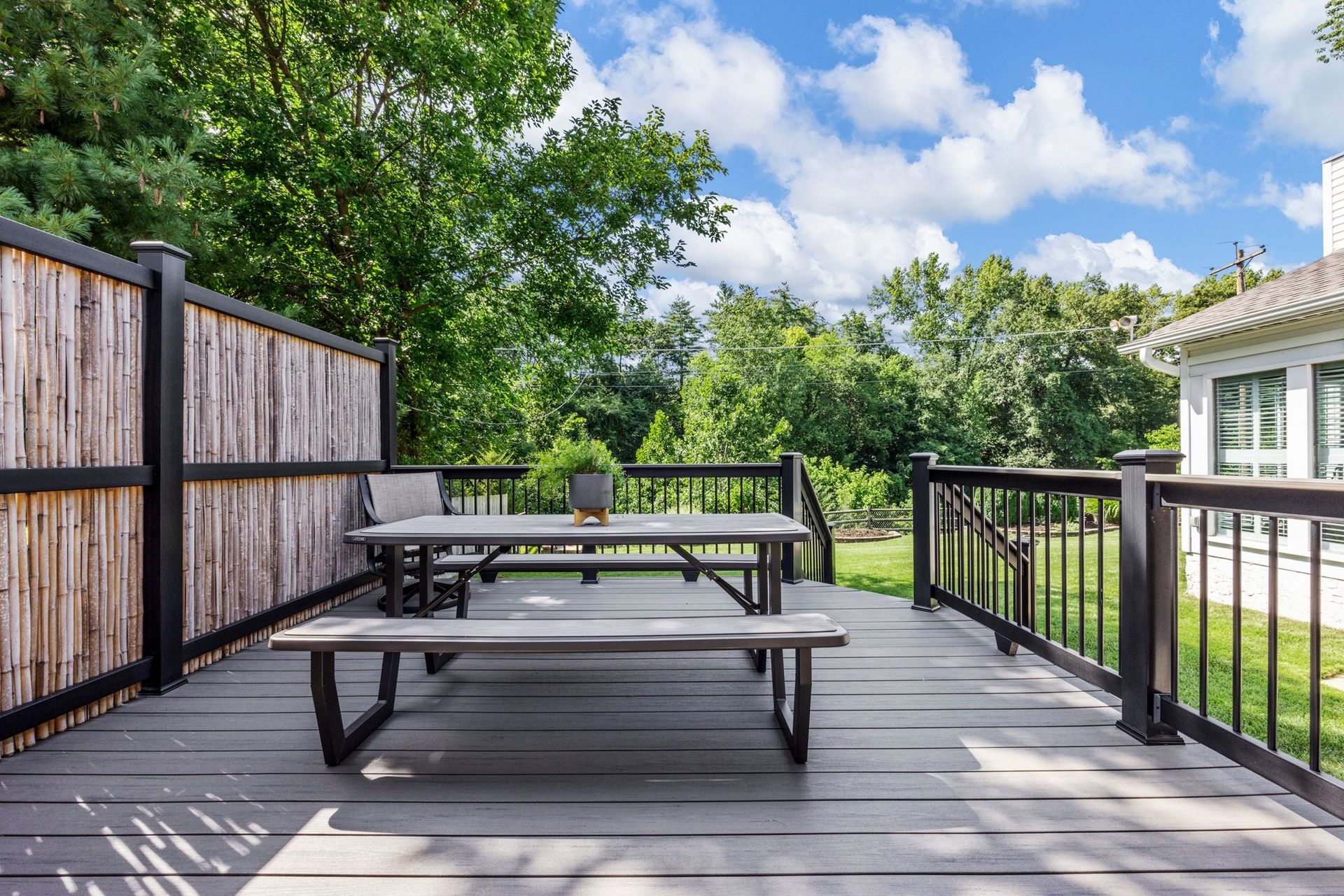 A wooden deck with a picnic table and benches