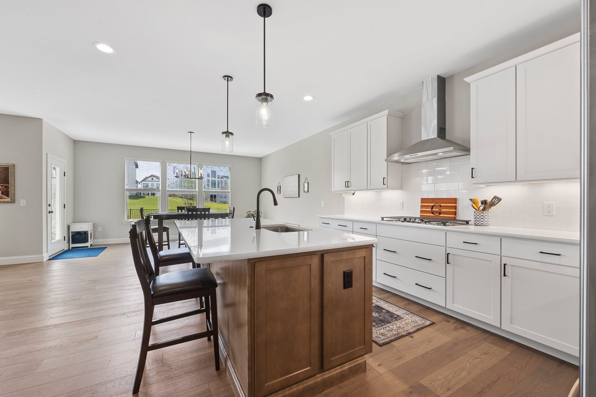 A kitchen with white cabinets and a large island in the middle.