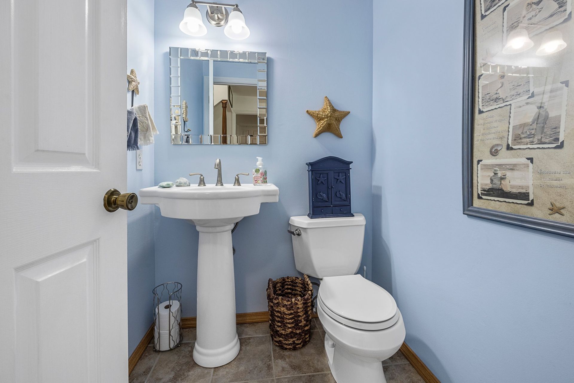 A bathroom with a toilet , sink and mirror.