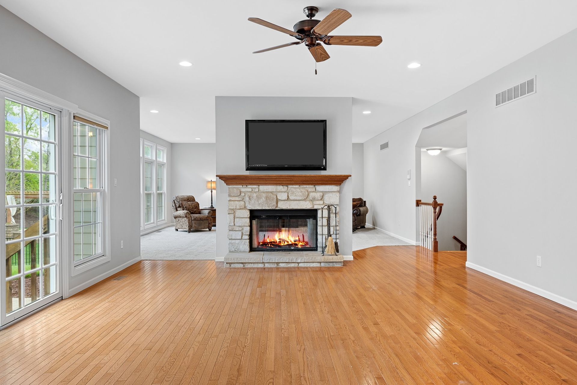 A living room with a fireplace , television and ceiling fan.