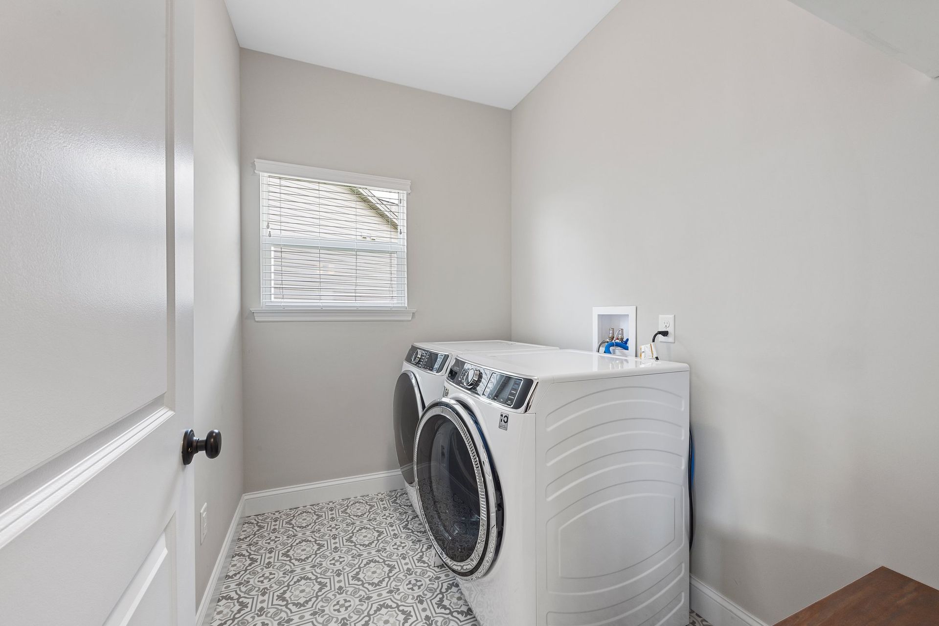A laundry room with a washer and dryer and a window.
