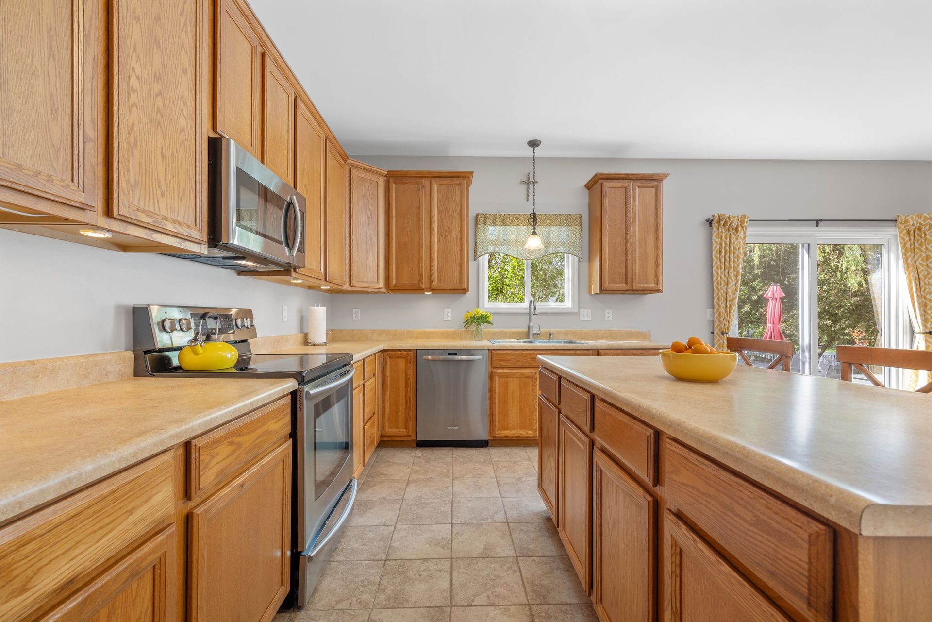 A kitchen with wooden cabinets , stainless steel appliances , and a large island.