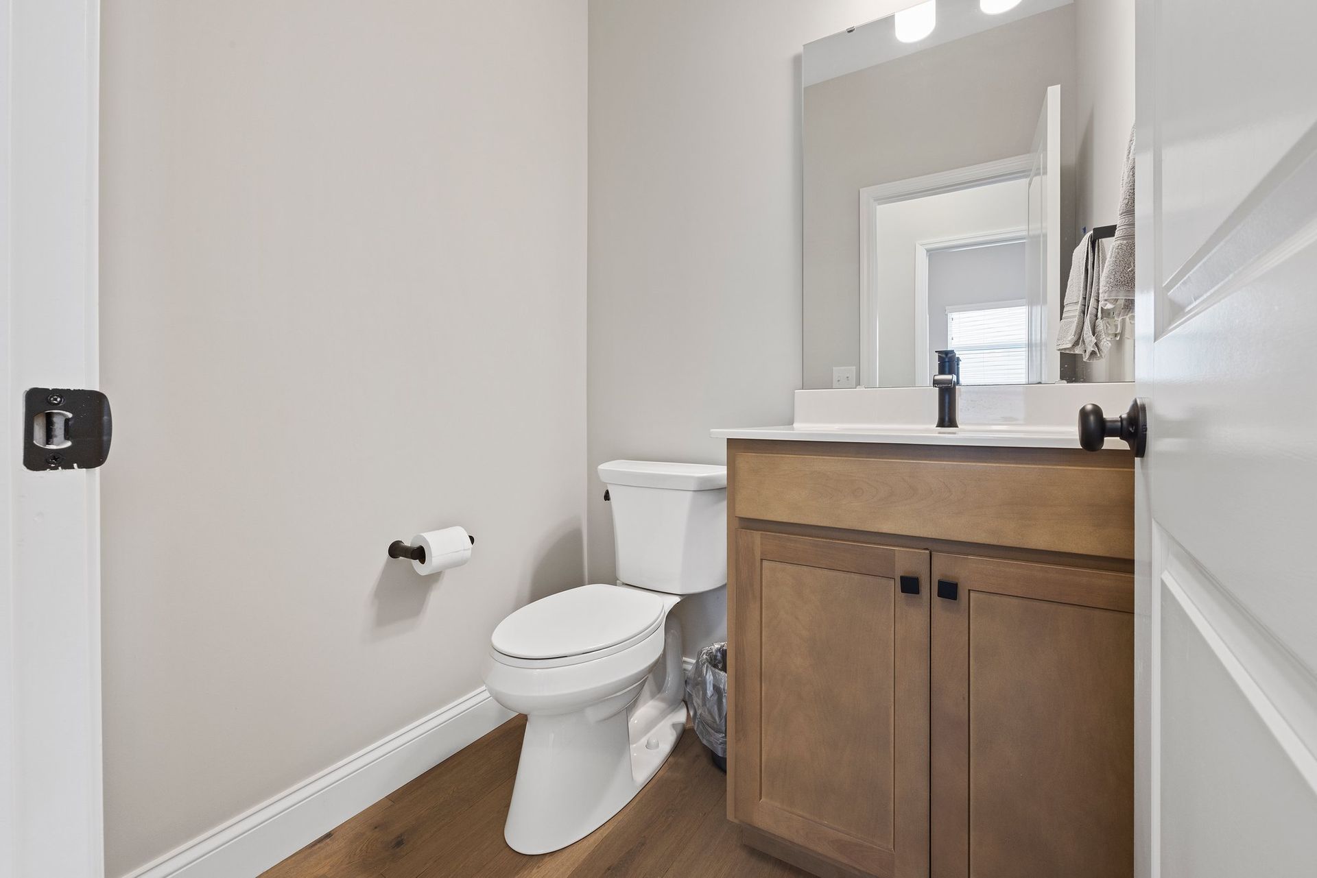 A bathroom with a toilet , sink and mirror.