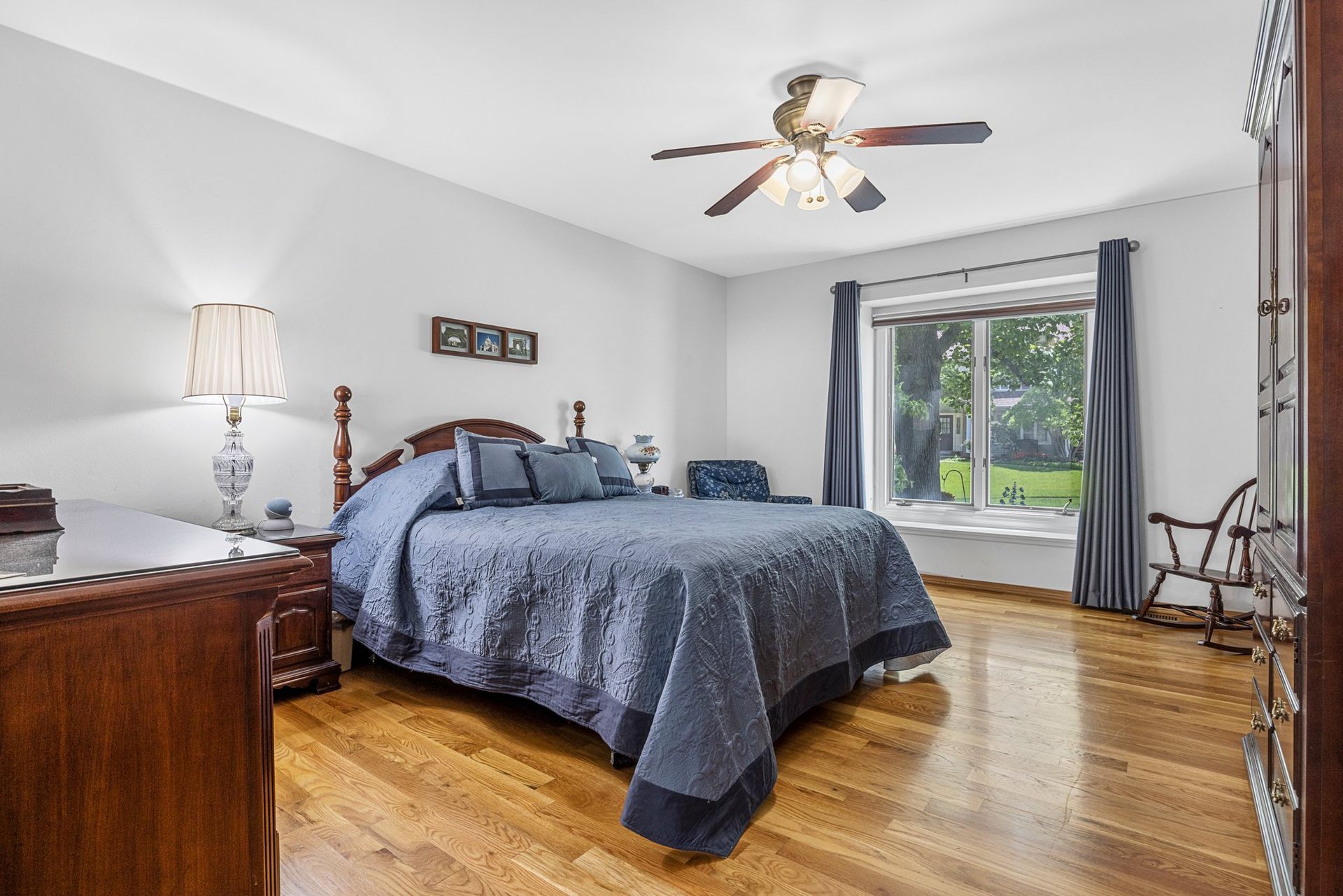 A bedroom with a large bed and a ceiling fan.