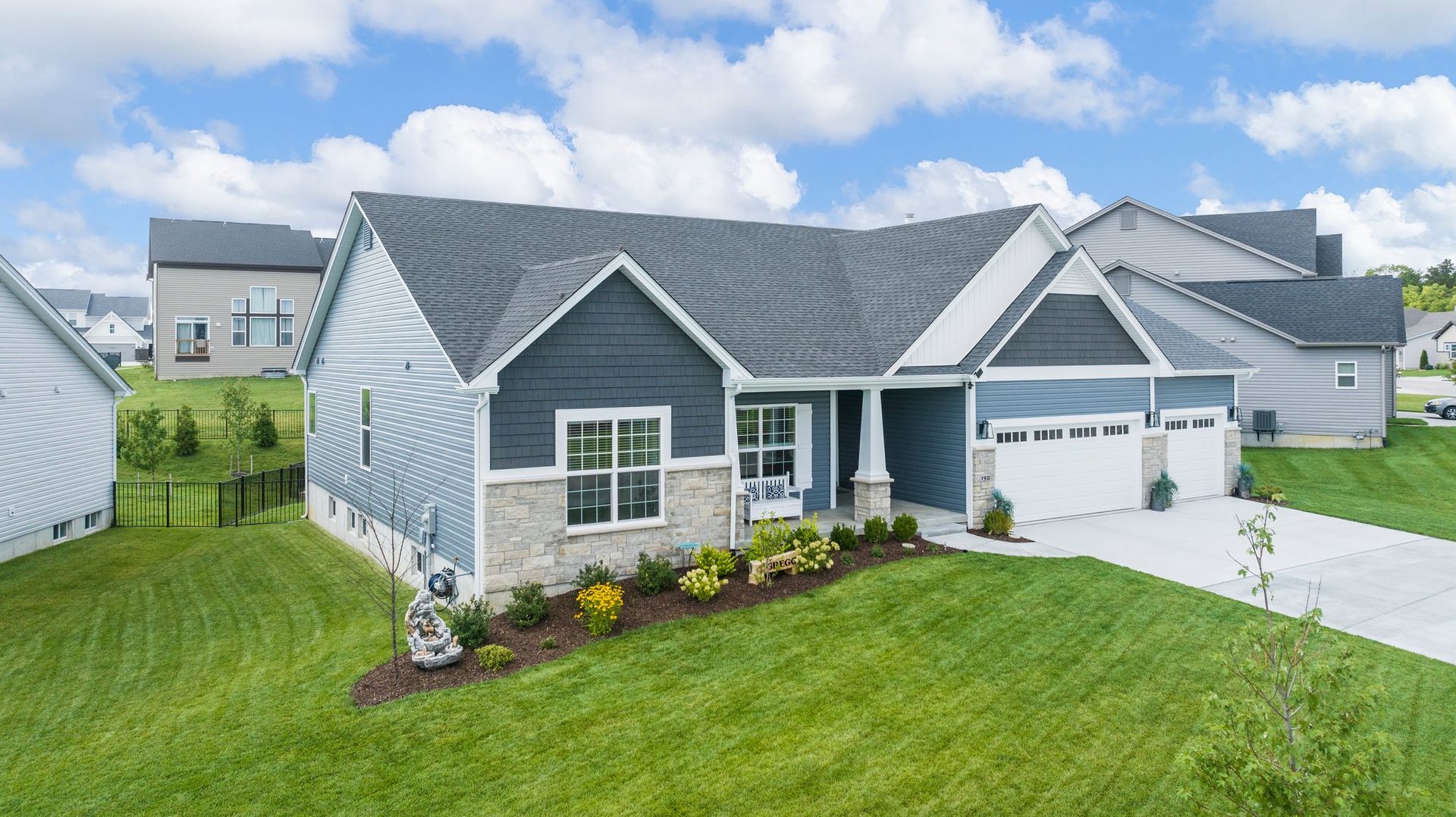 An aerial view of a house with a large lawn in front of it.