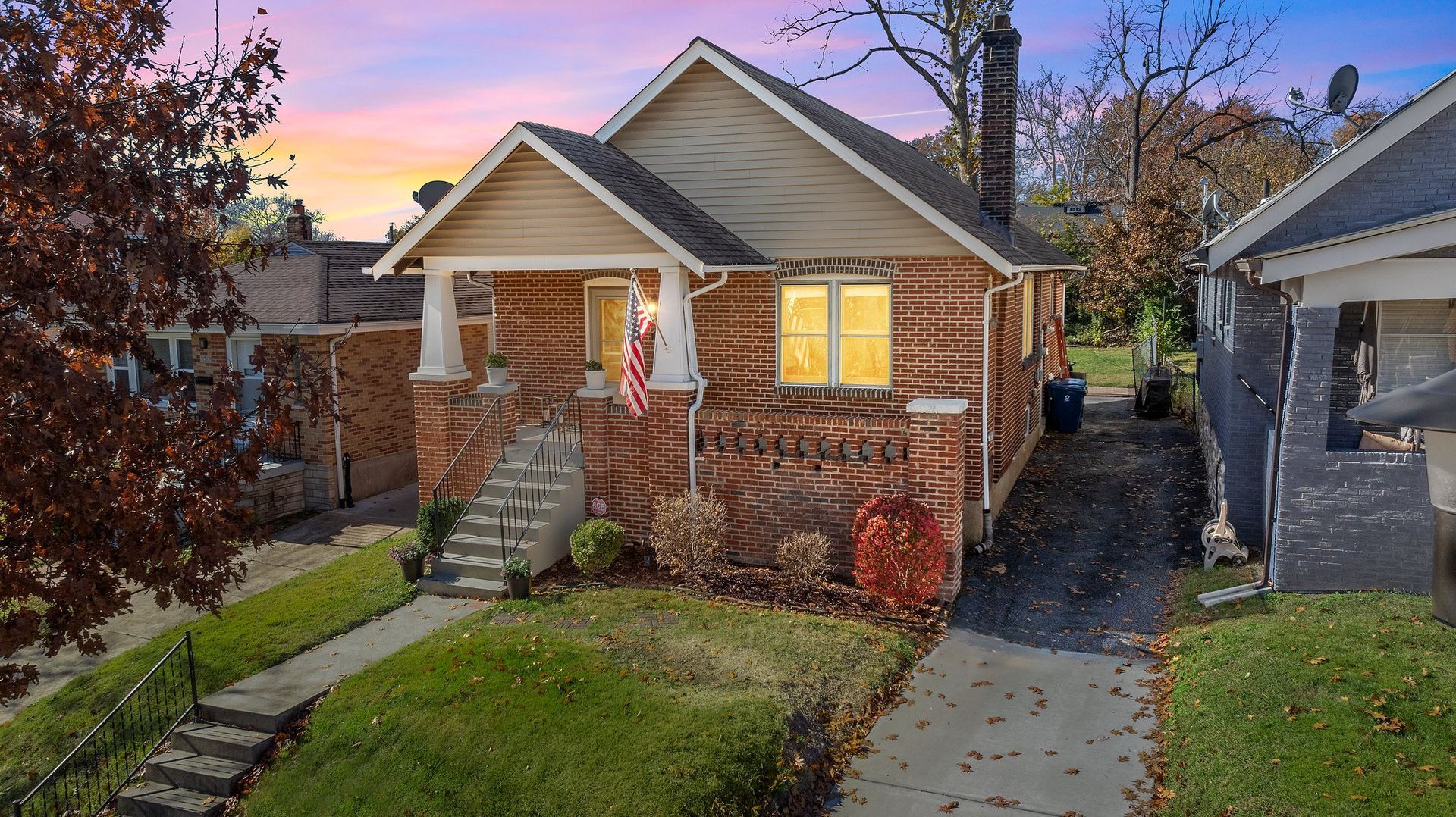 A large brick house with two garages and a lush green lawn