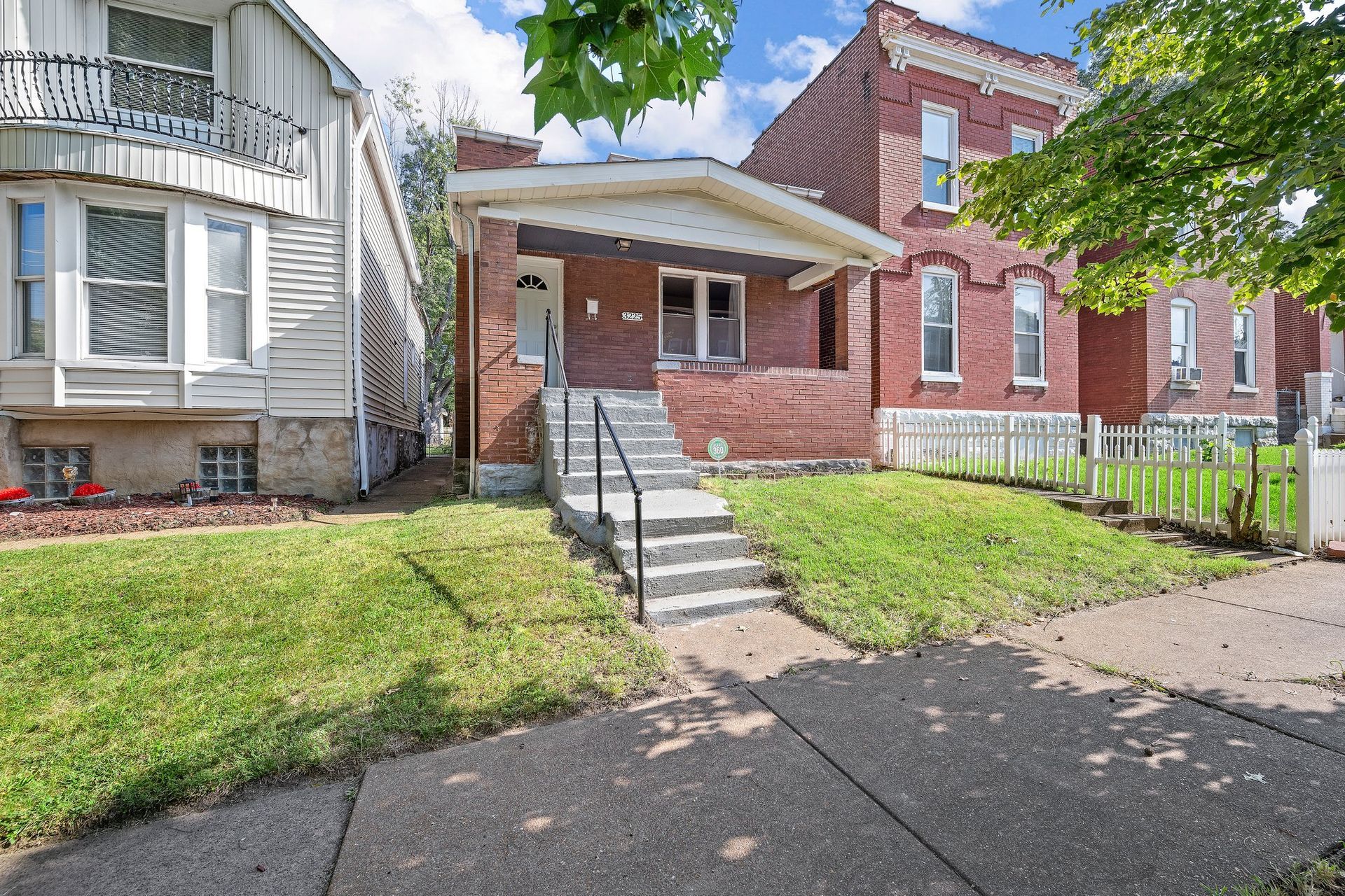A brick house with stairs leading up to the front door.