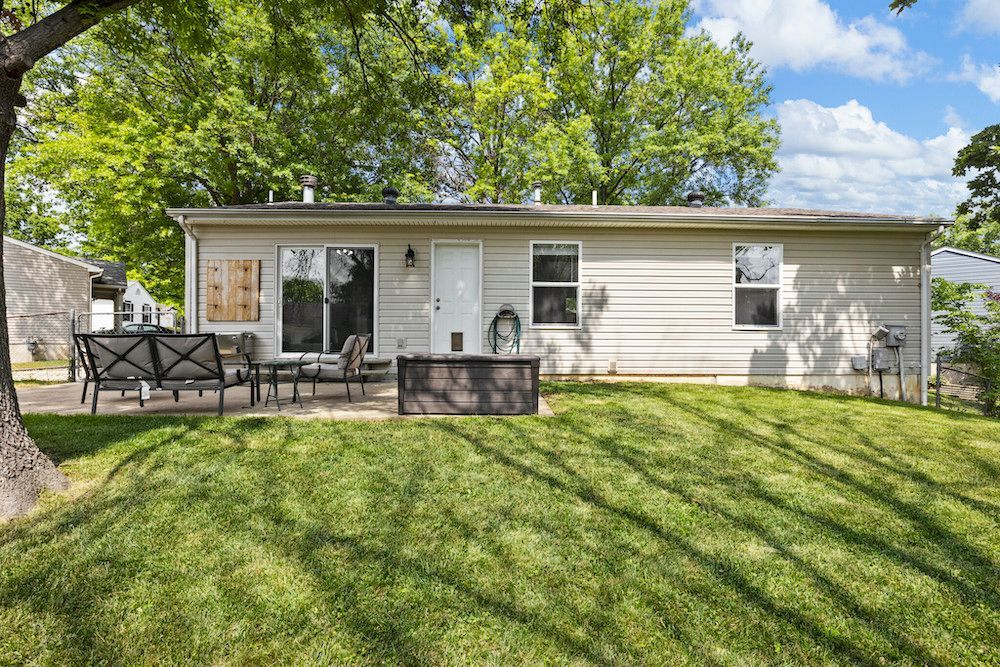 A small house with a large lawn in front of it.