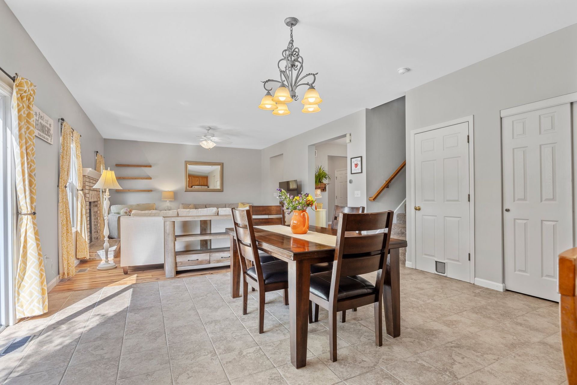 A living room with a dining table and chairs and a chandelier.