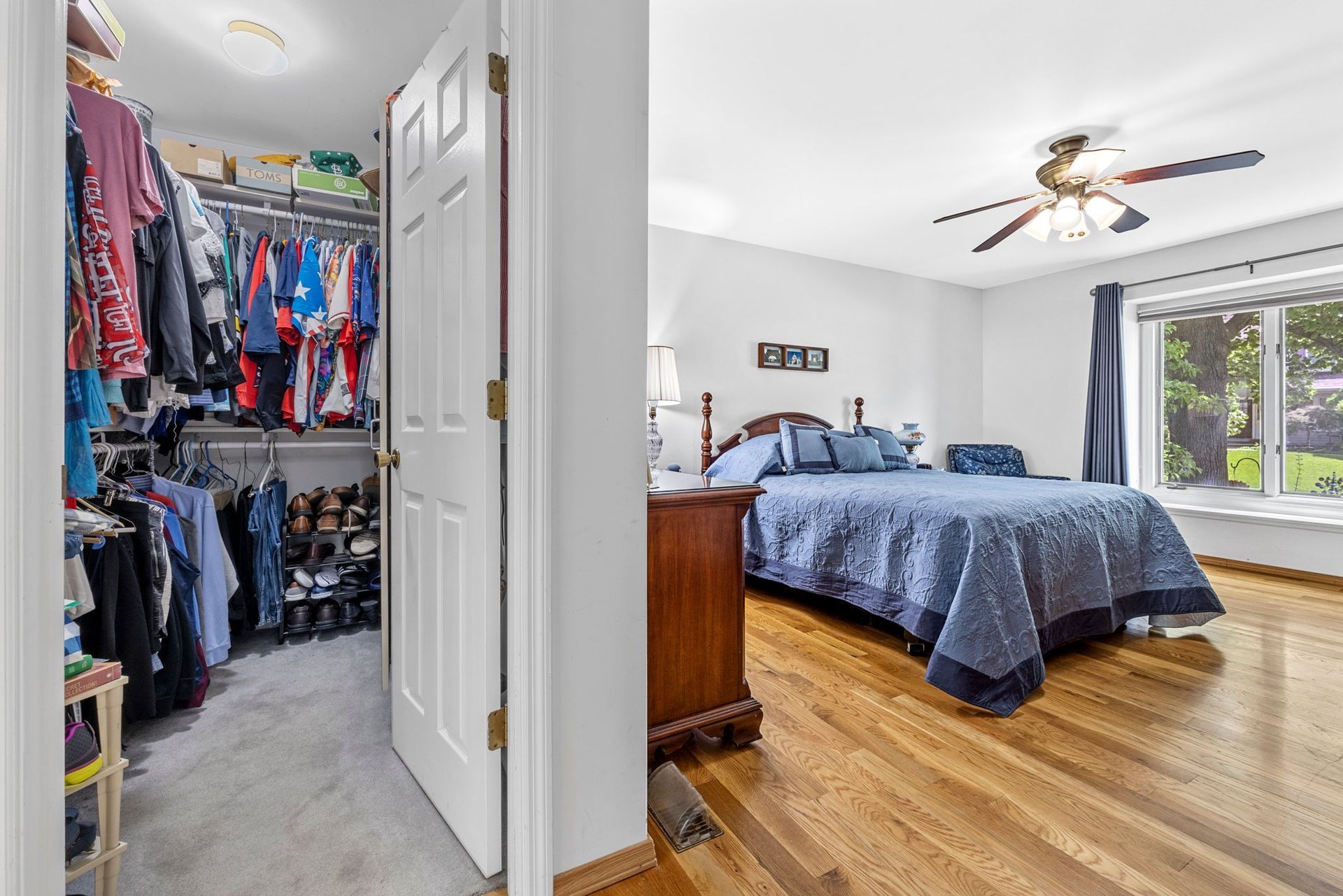 A bedroom with a large bed and a walk in closet.