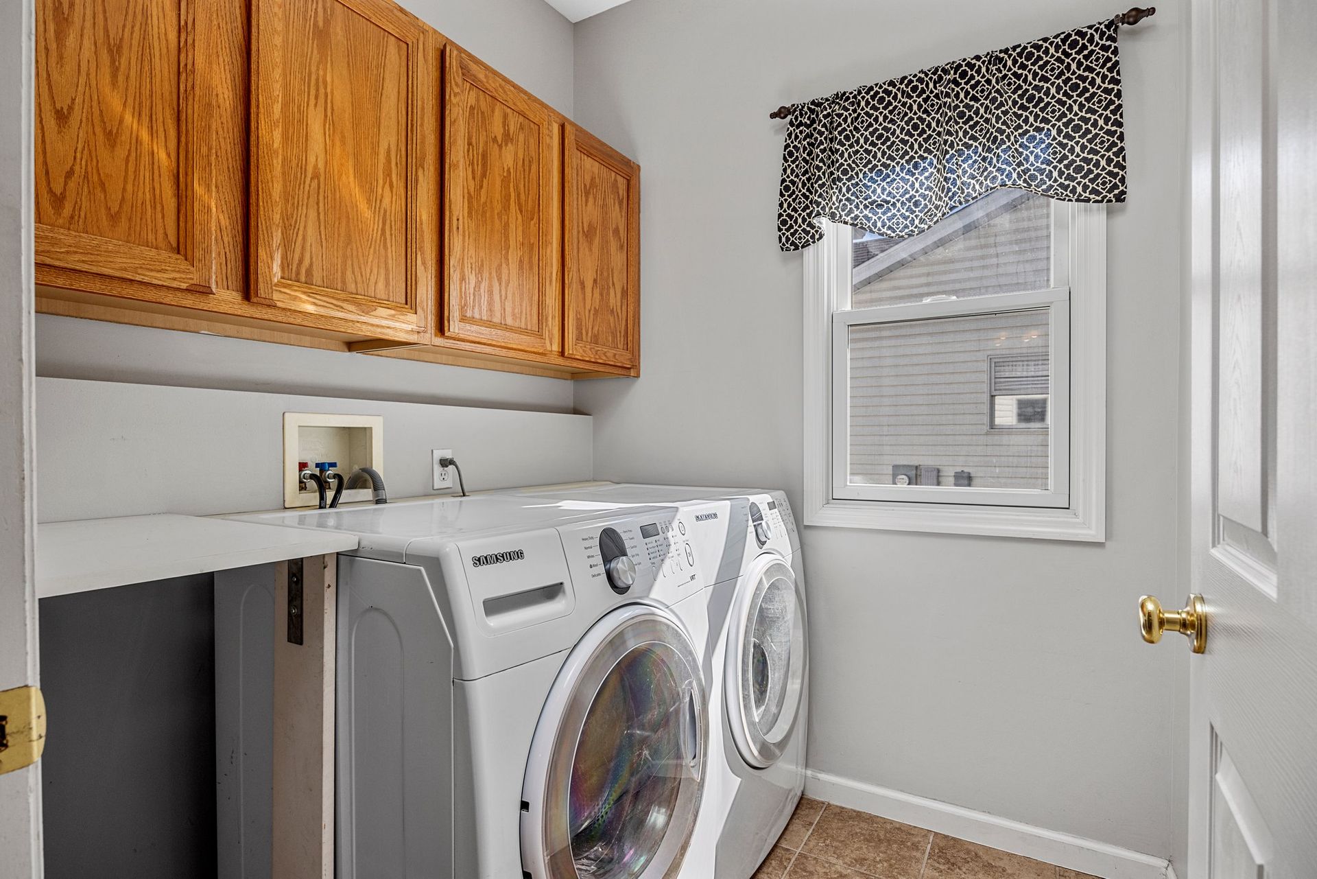 A laundry room with a washer and dryer and a window.