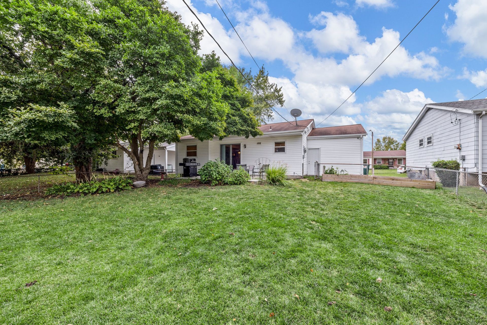 The backyard of a house with a lot of grass and trees.
