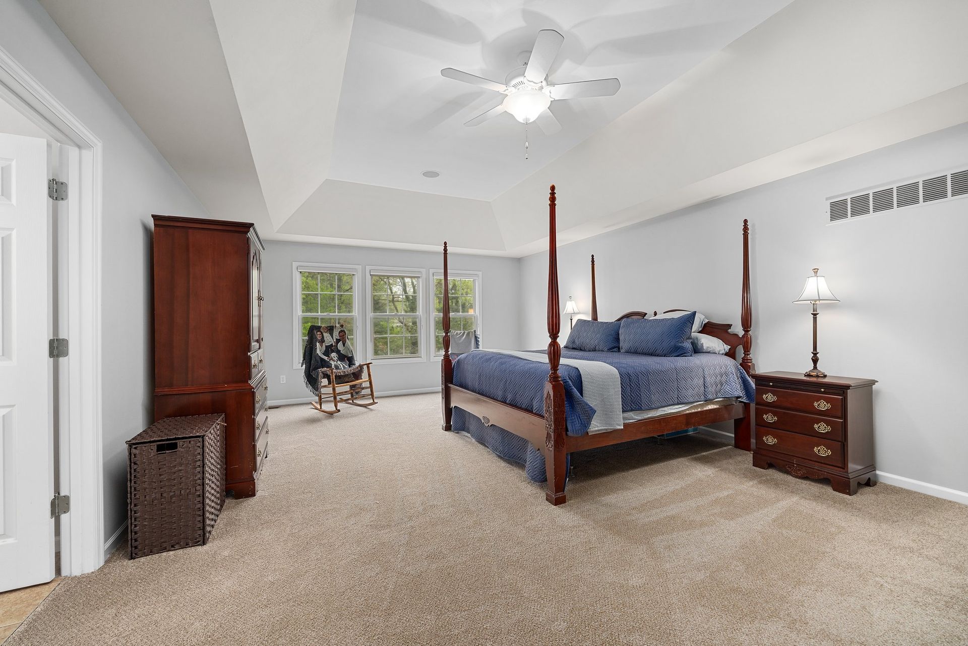 A bedroom with a four poster bed and a ceiling fan.