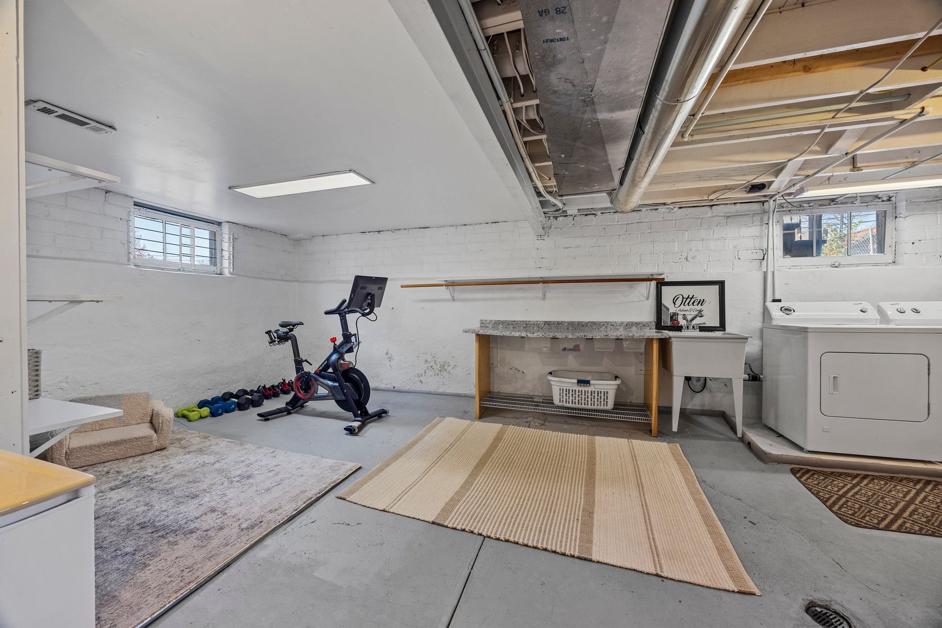 A basement with a bicycle and a washer and dryer.