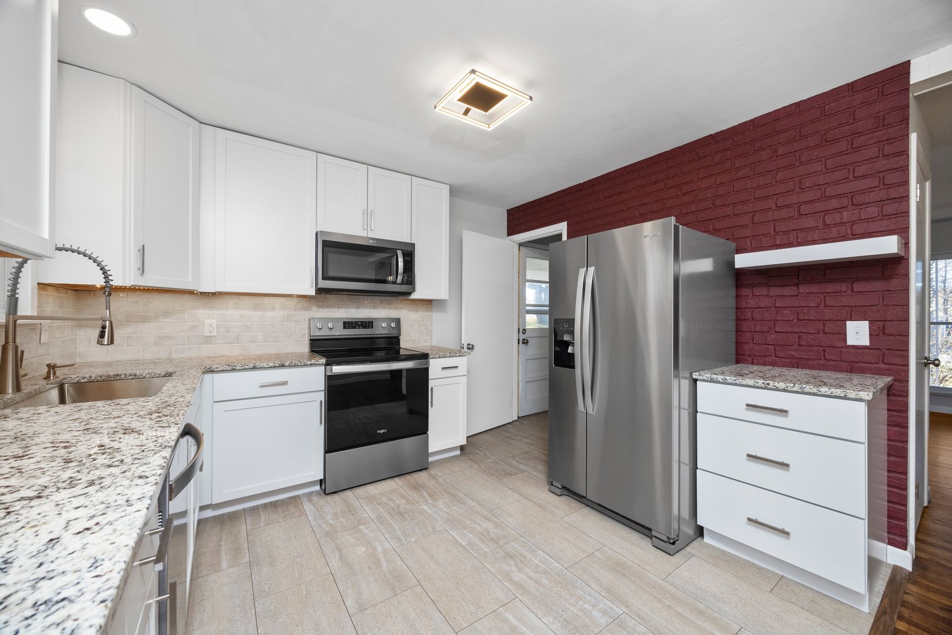 A kitchen with white cabinets and stainless steel appliances
