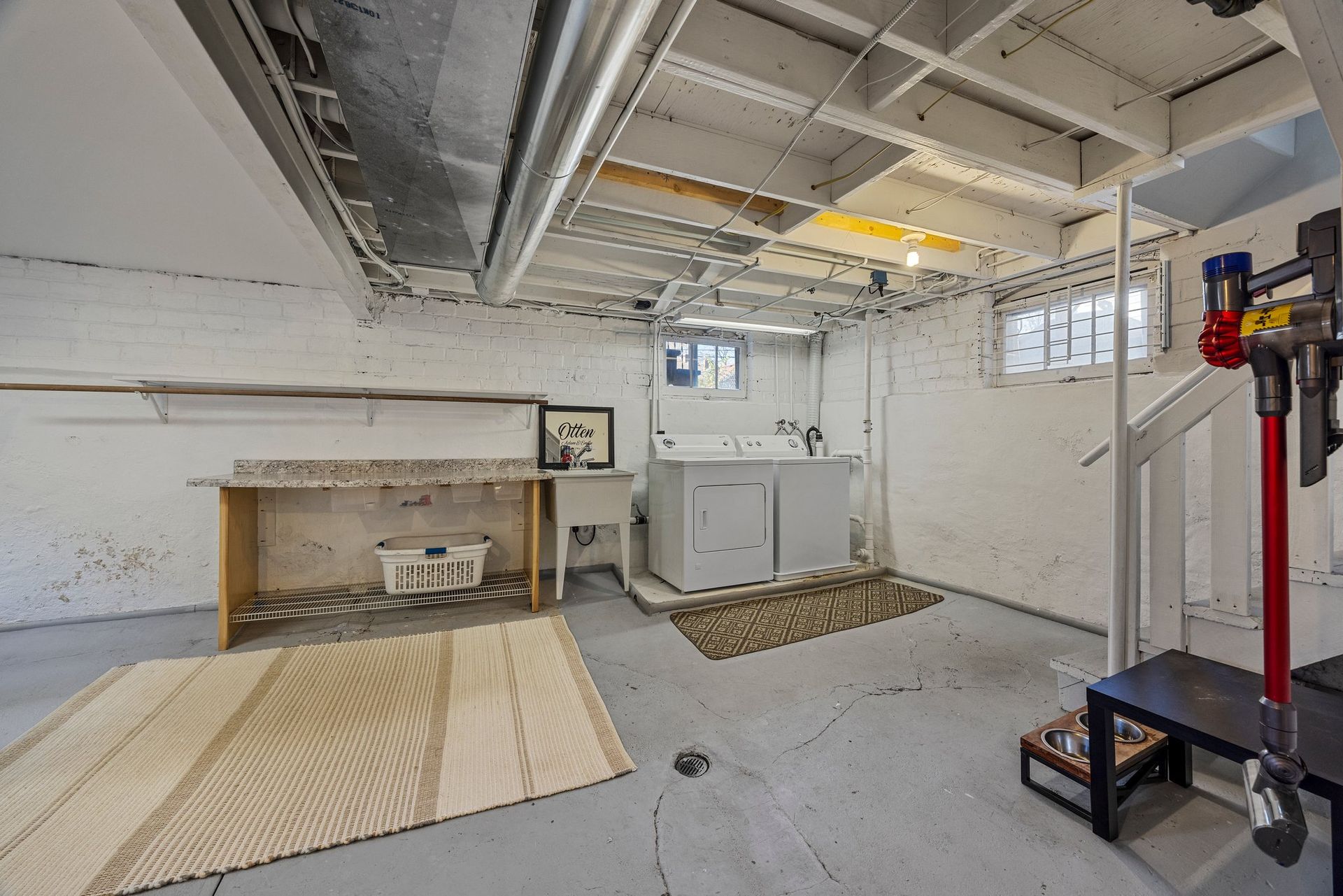A laundry room in a basement with a washer and dryer.