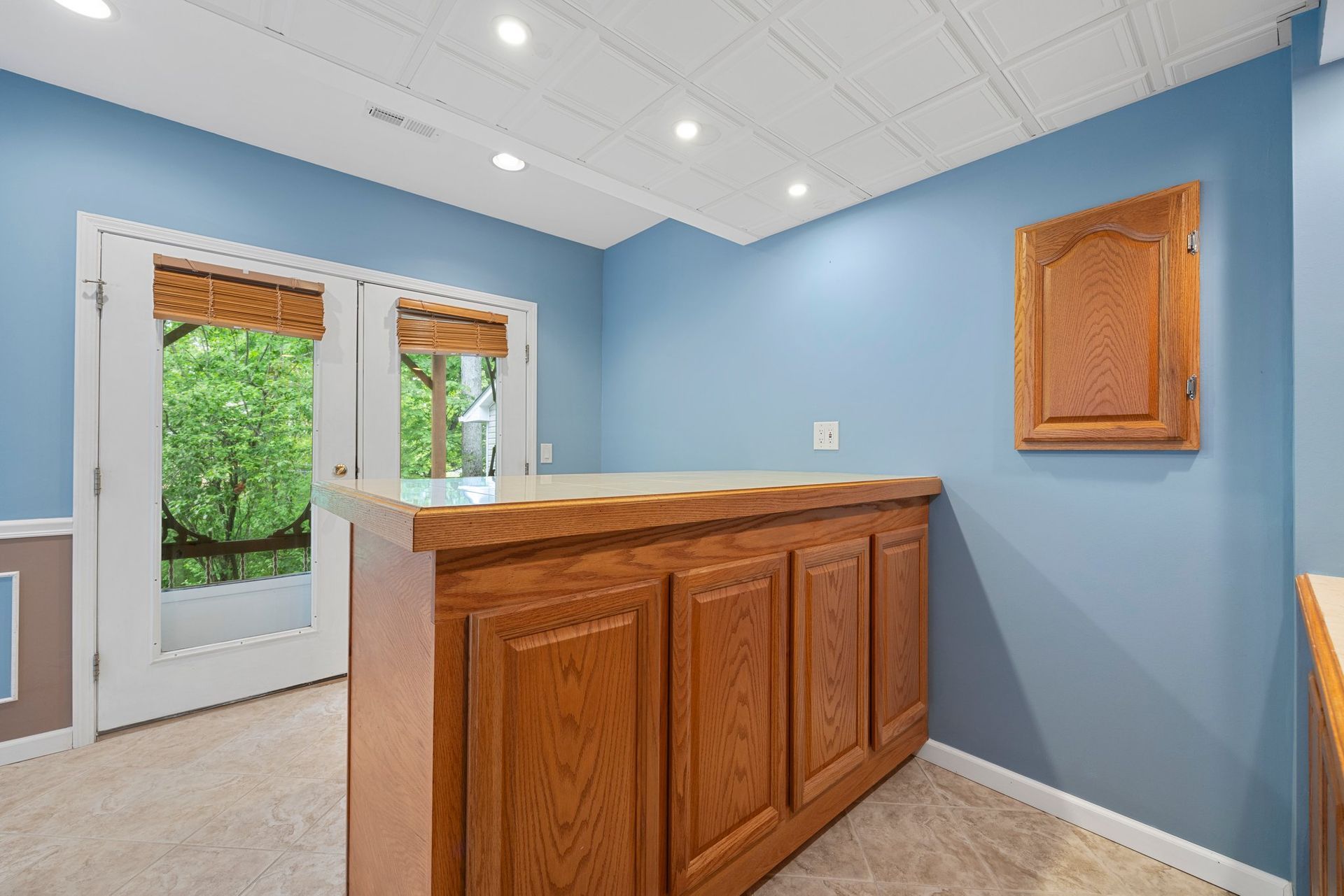 There is a bar in the middle of the room with blue walls.