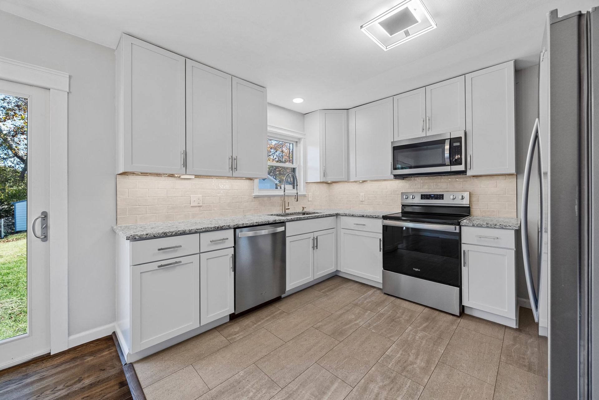 A kitchen with white cabinets and stainless steel appliances.
