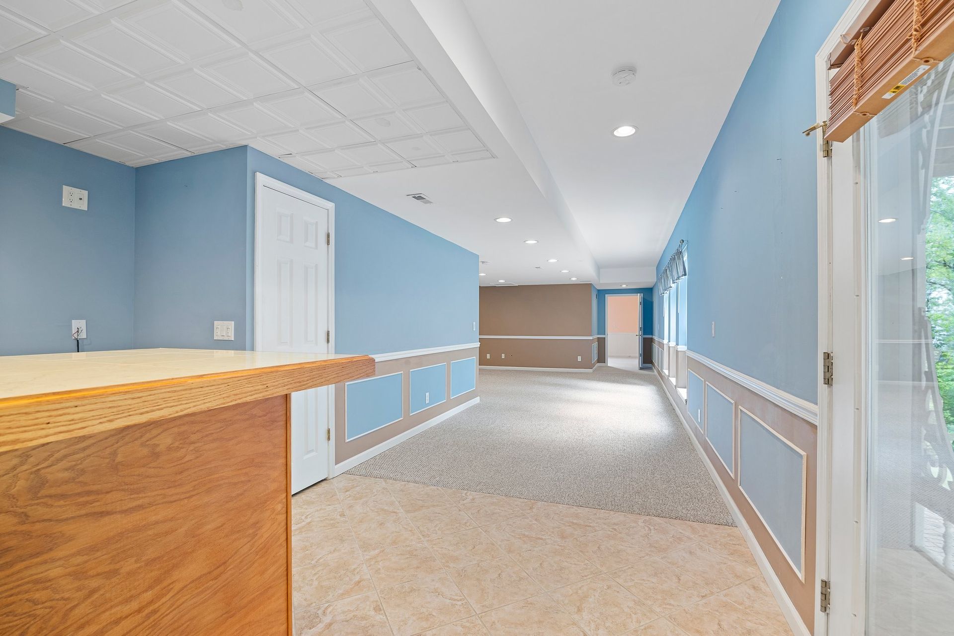 An empty basement with blue walls and a wooden counter.
