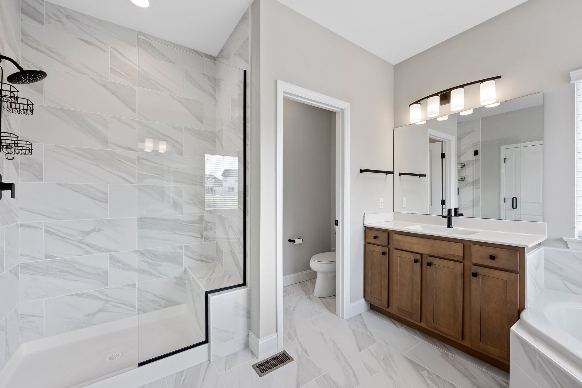 A bathroom with a walk in shower , sink , toilet and bathtub.