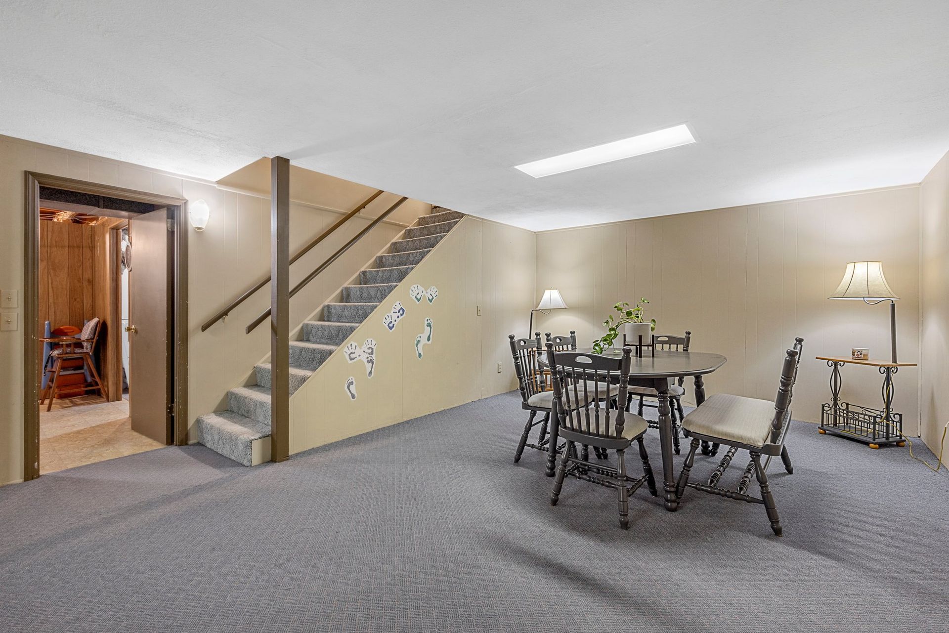 A basement with a table and chairs and stairs.