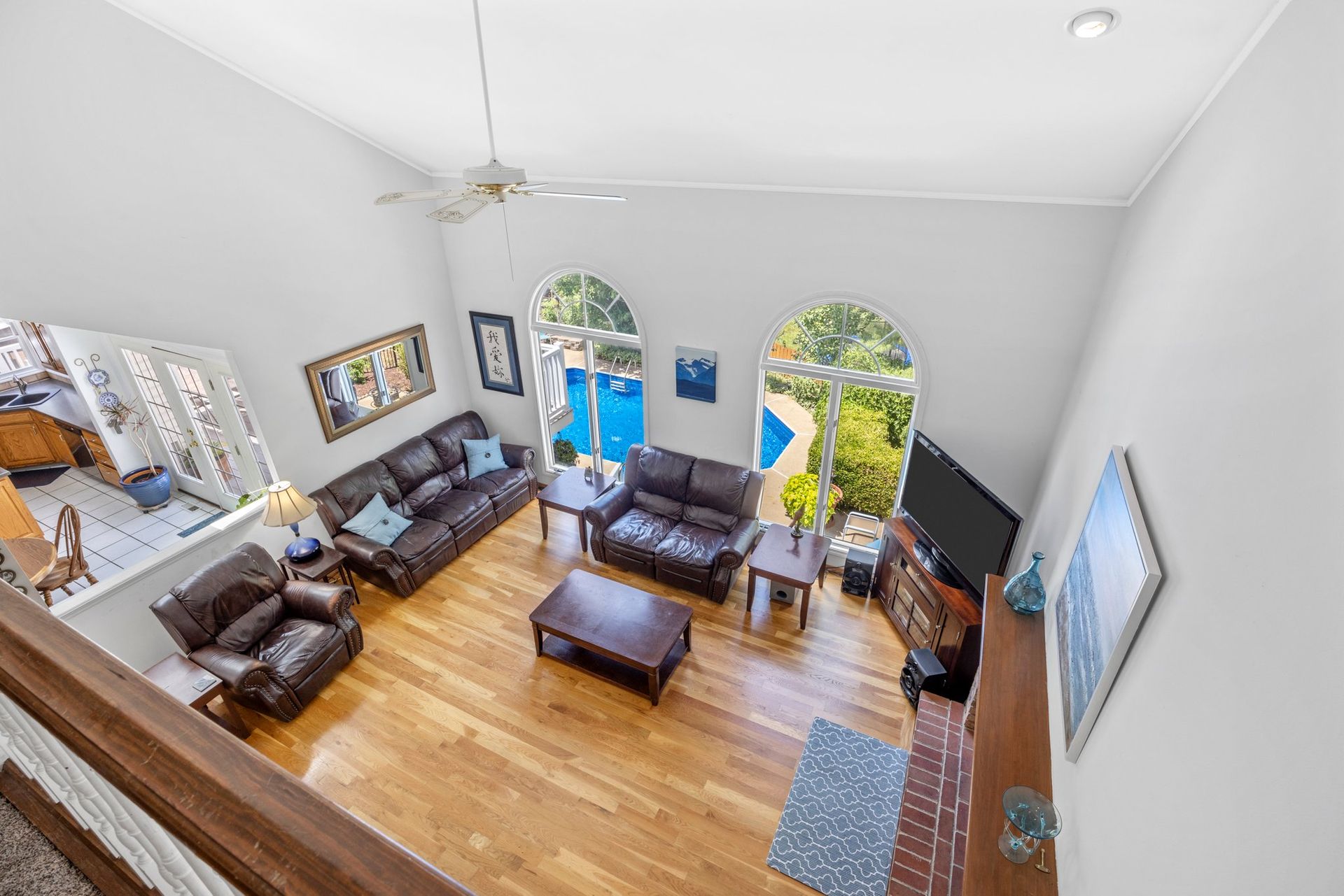 An aerial view of a living room filled with furniture and a ceiling fan.
