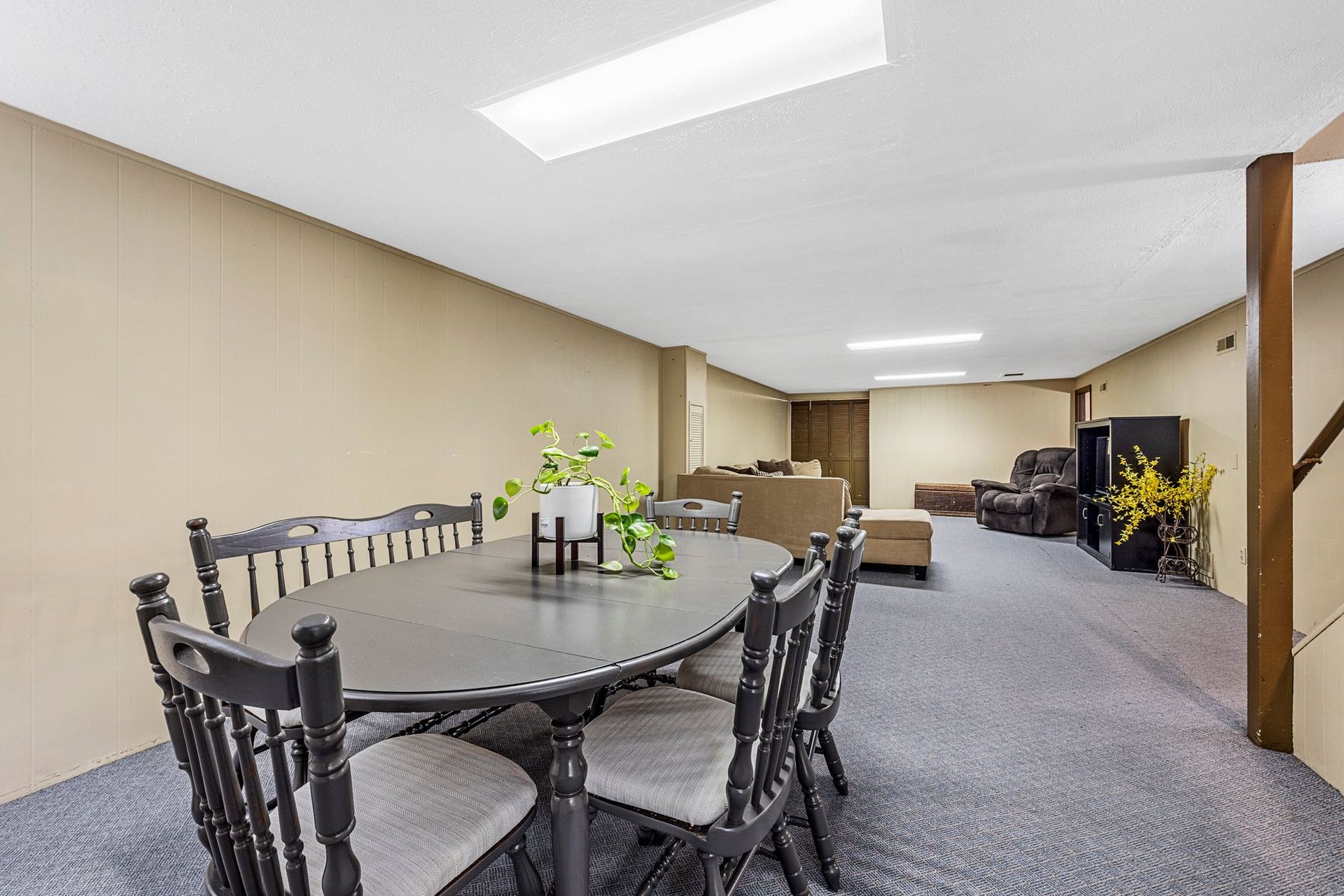 A basement with a table and chairs in it.