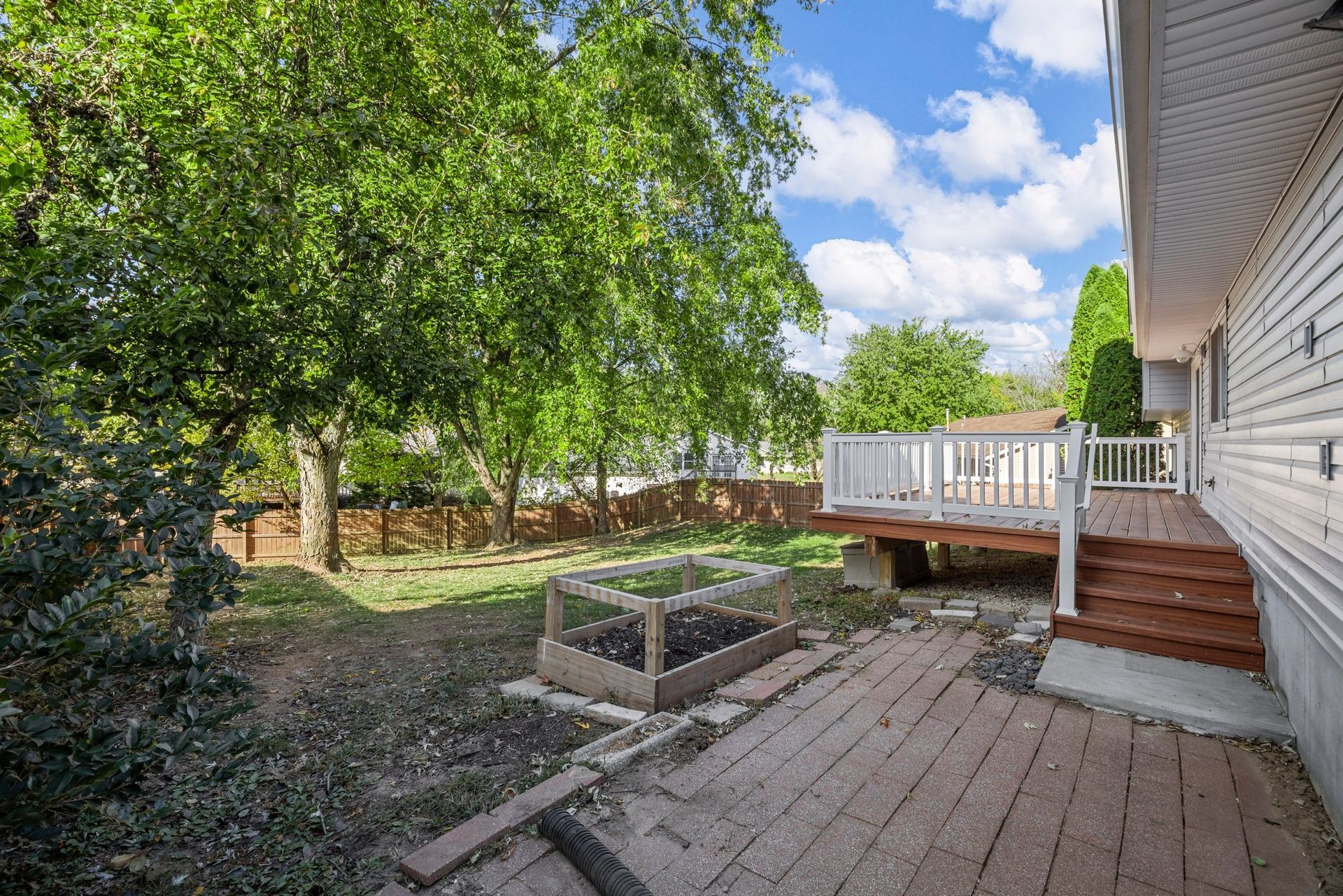 There is a deck in the backyard of a house.