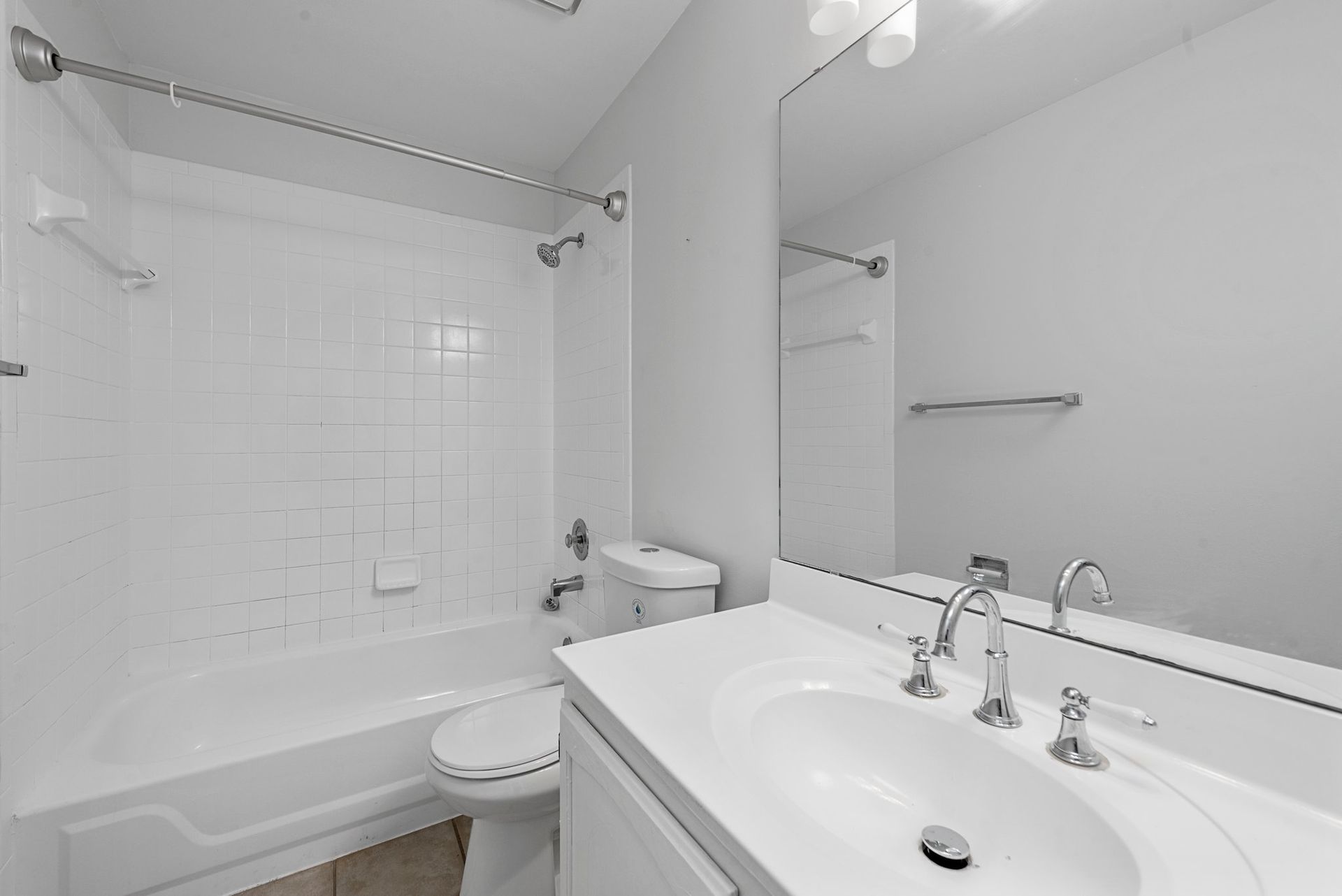 A bathroom with a sink , toilet , bathtub and mirror.