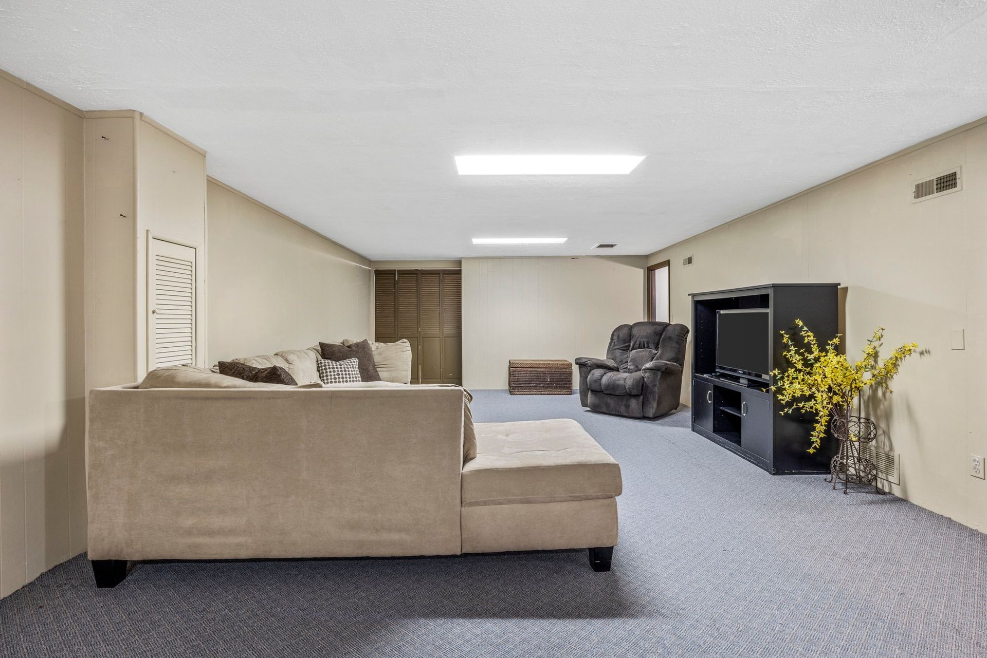 A living room with a couch , chair , and television.