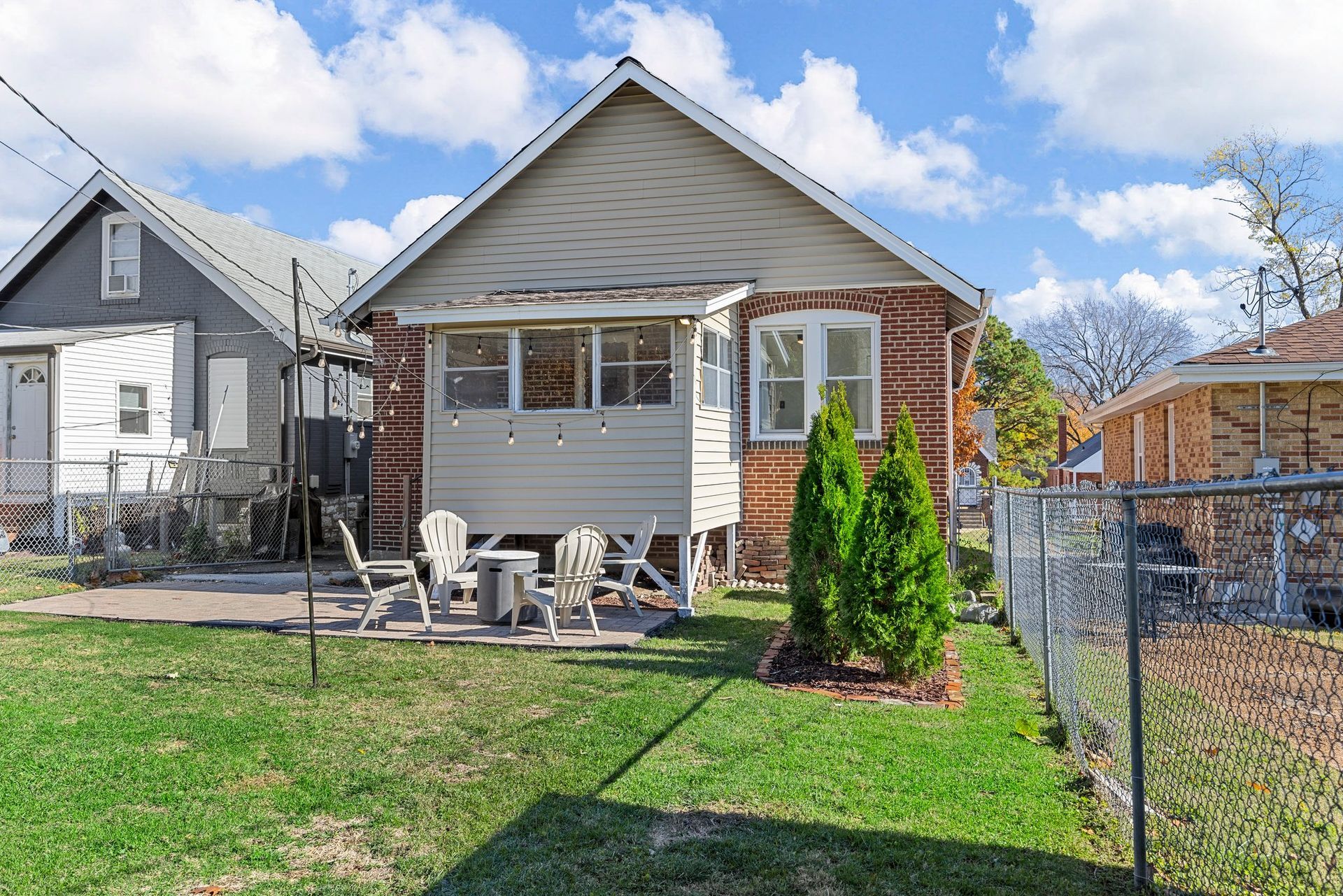 A small house with a patio and chairs in front of it.