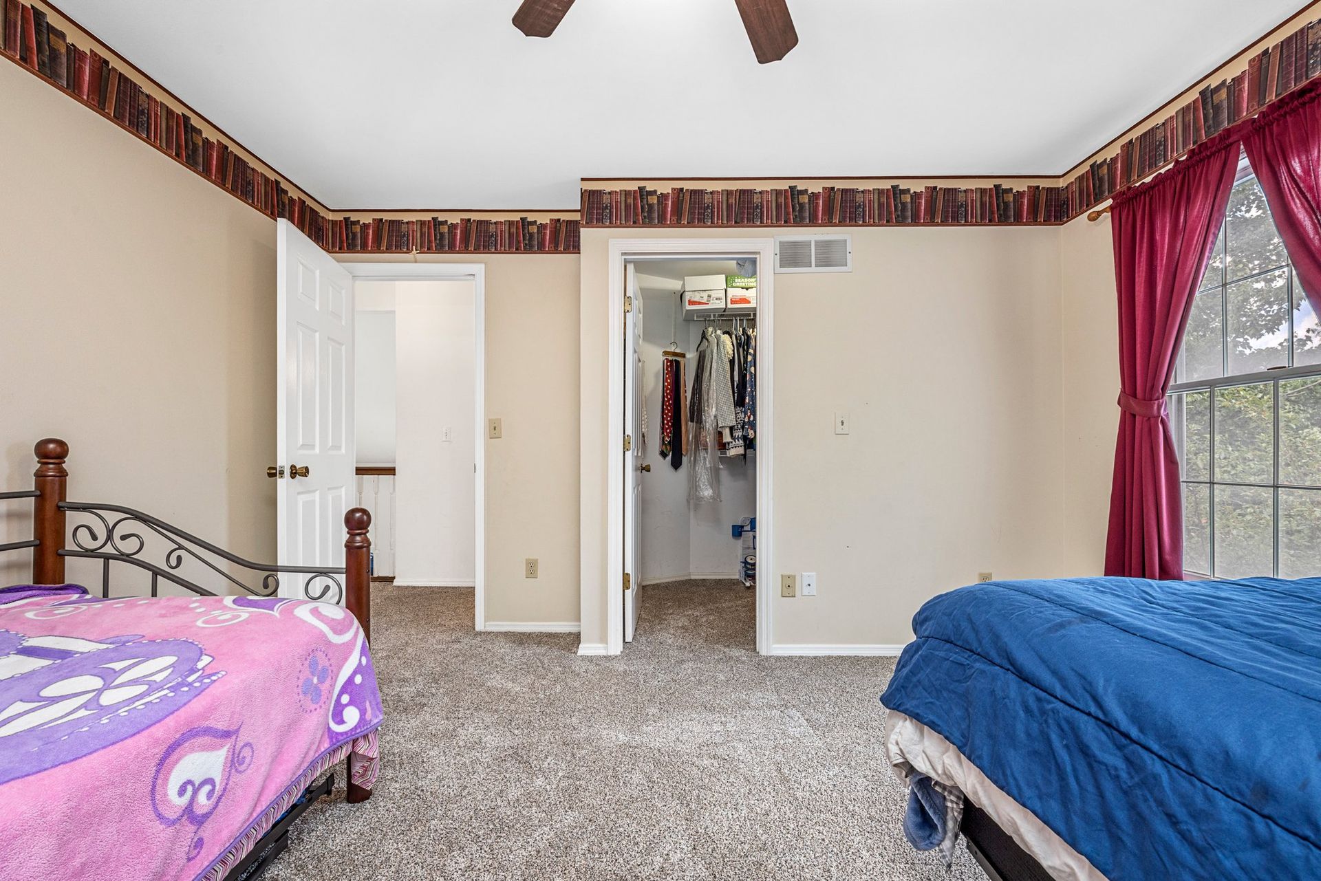 A bedroom with two beds and a ceiling fan.